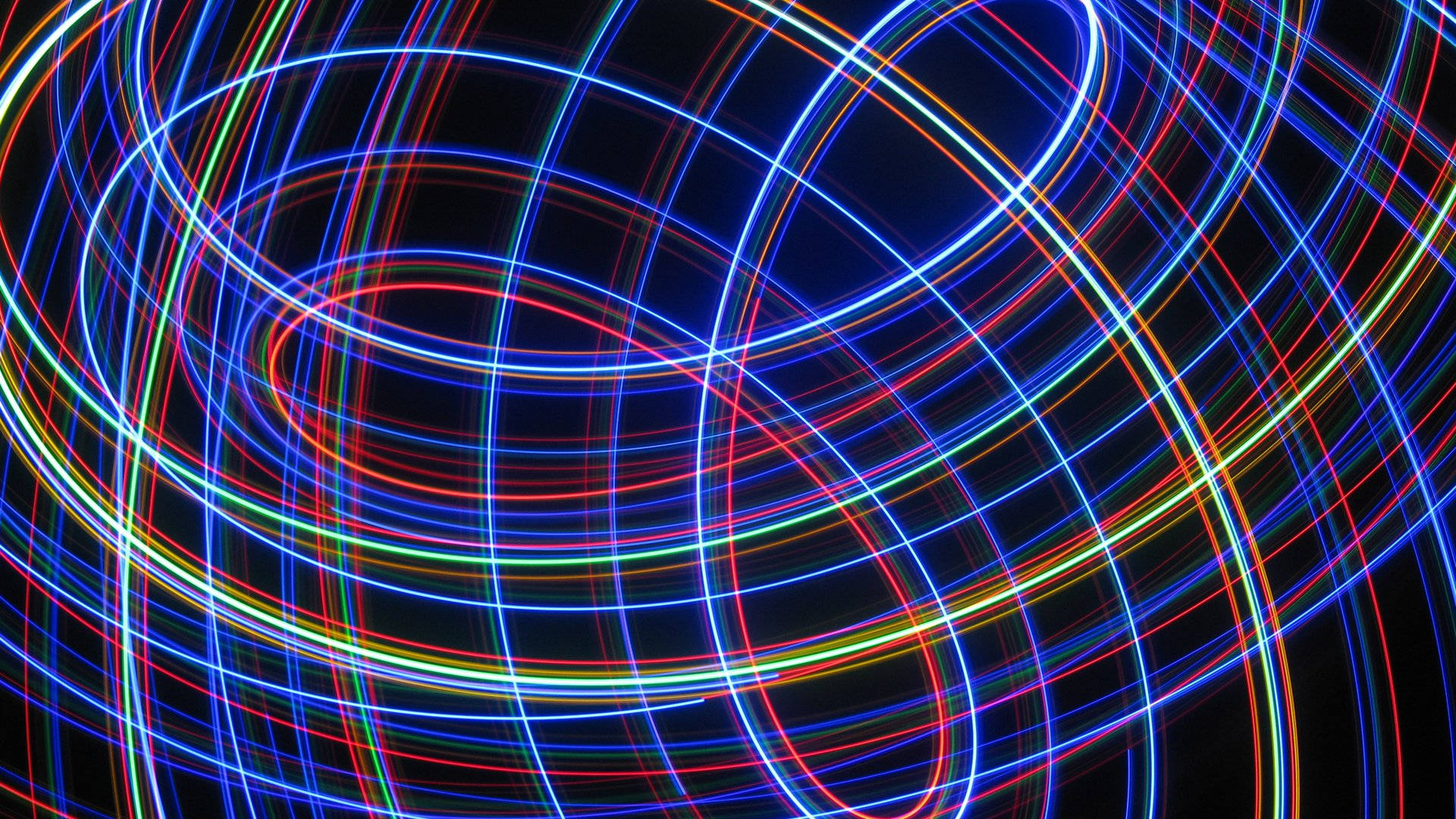 LED 桌布 壁紙 — 充滿活力的霓虹燈光軌跡在深黑色背景上以動態圖案旋轉，營造出未來主義的抽象光芒。