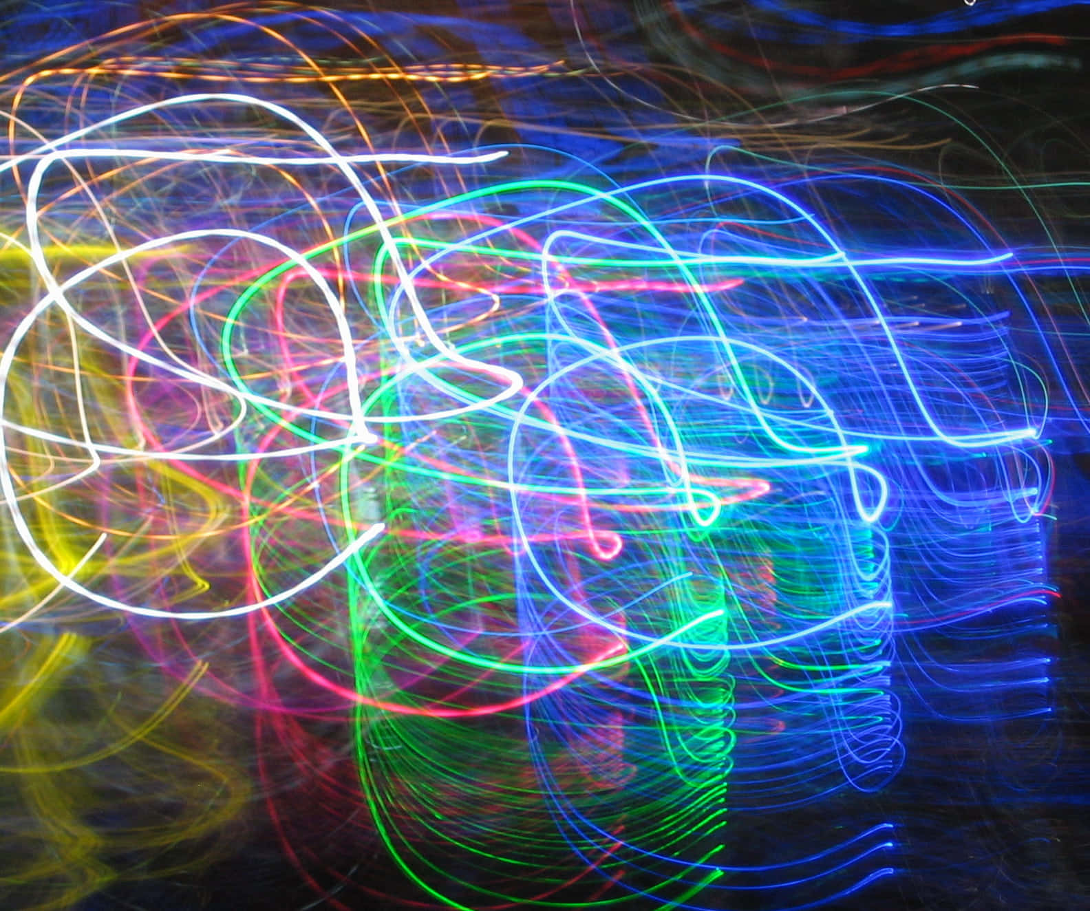 Trippy Neon Lights 桌布 壁紙 — 充滿活力的霓虹燈光軌跡在黑暗背景上以混亂的美麗旋轉，創造出電動抽象的色彩舞蹈。