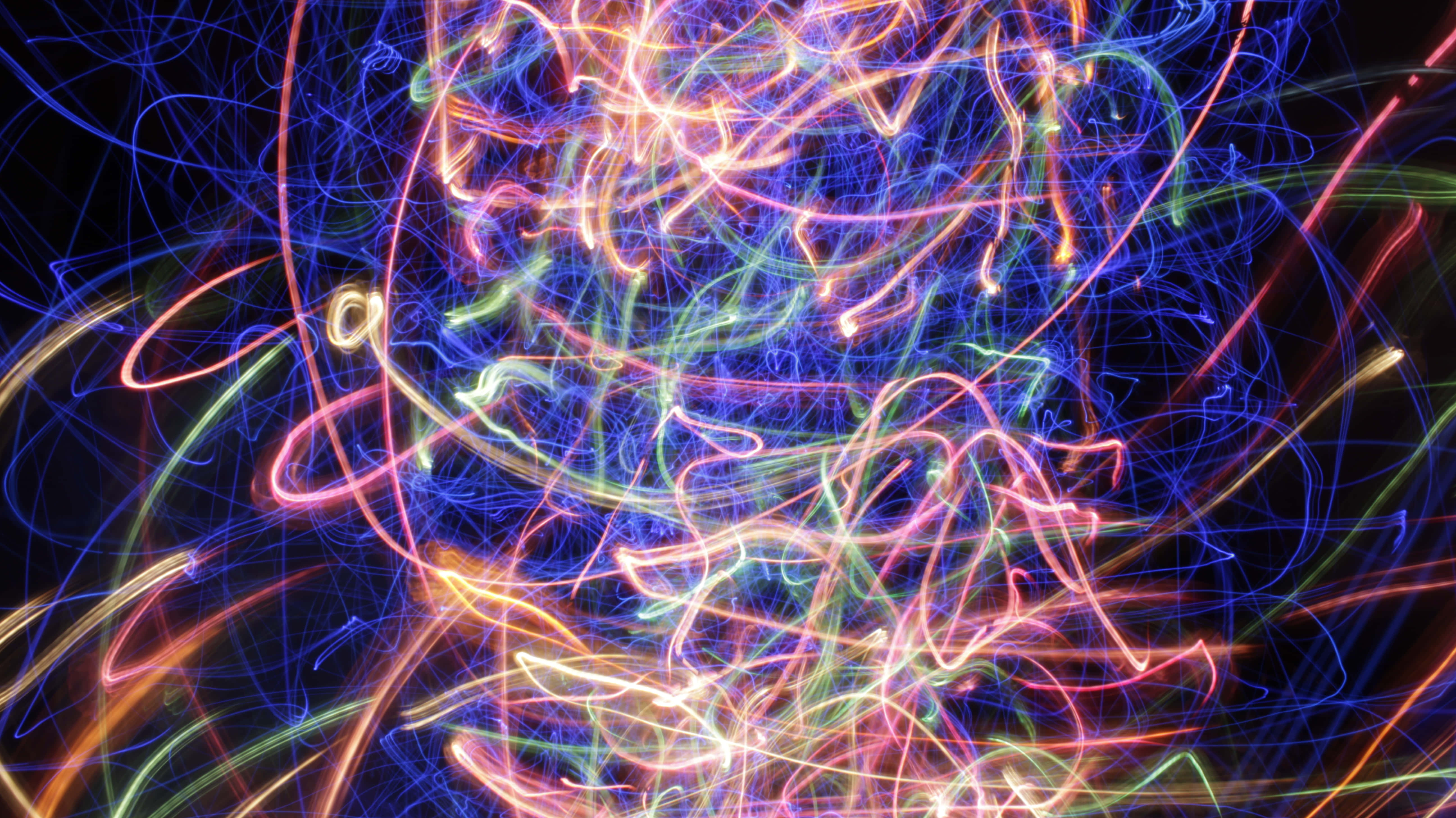Colorful Lines 桌布 壁紙 — 充滿活力的霓虹燈光軌跡在黑色背景上混亂地旋轉，形成動態的抽象構圖。