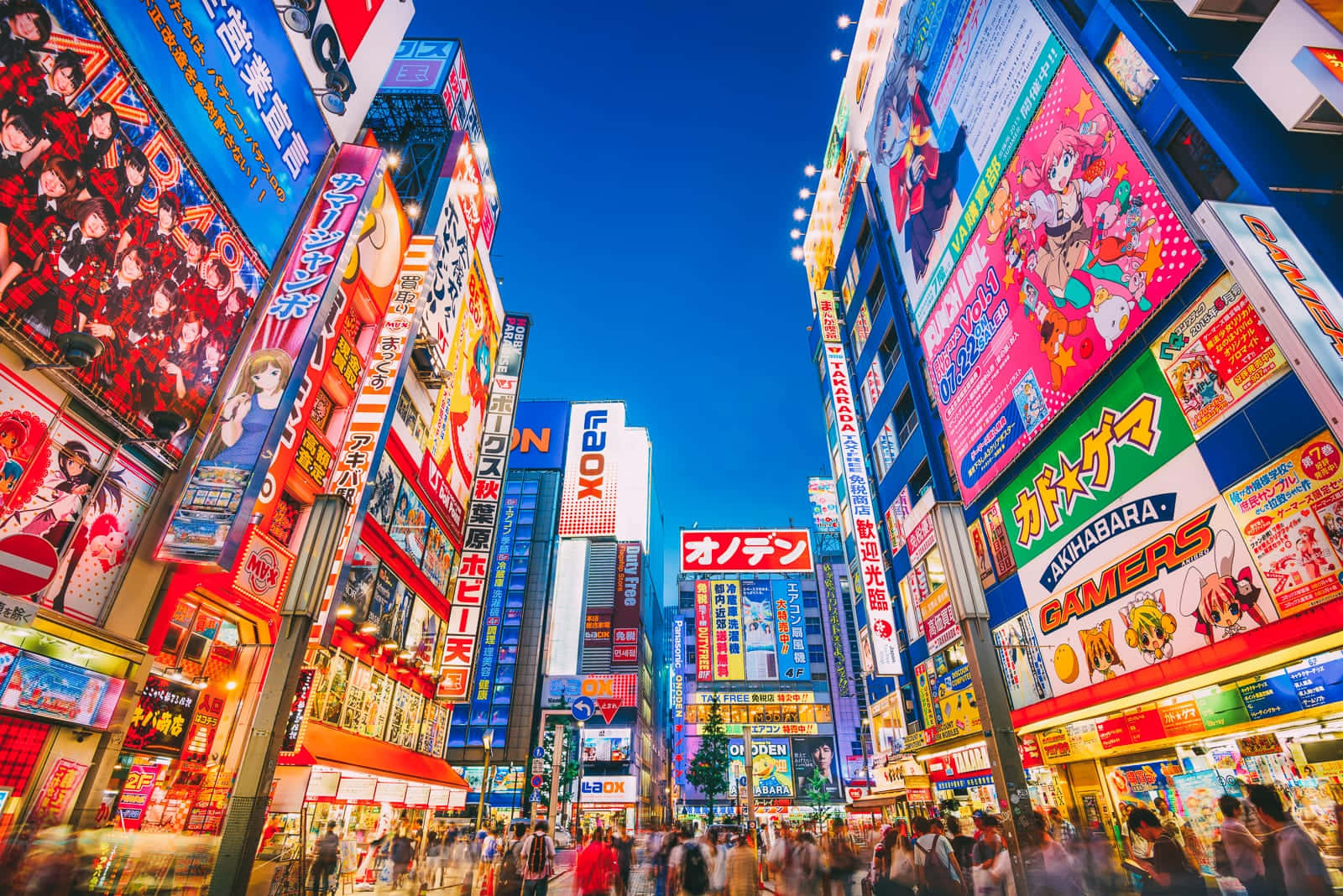 東京 桌布 壁紙 — 充滿活力的霓虹燈和高聳的動漫廣告牌照亮了暮色中繁華的東京街道。