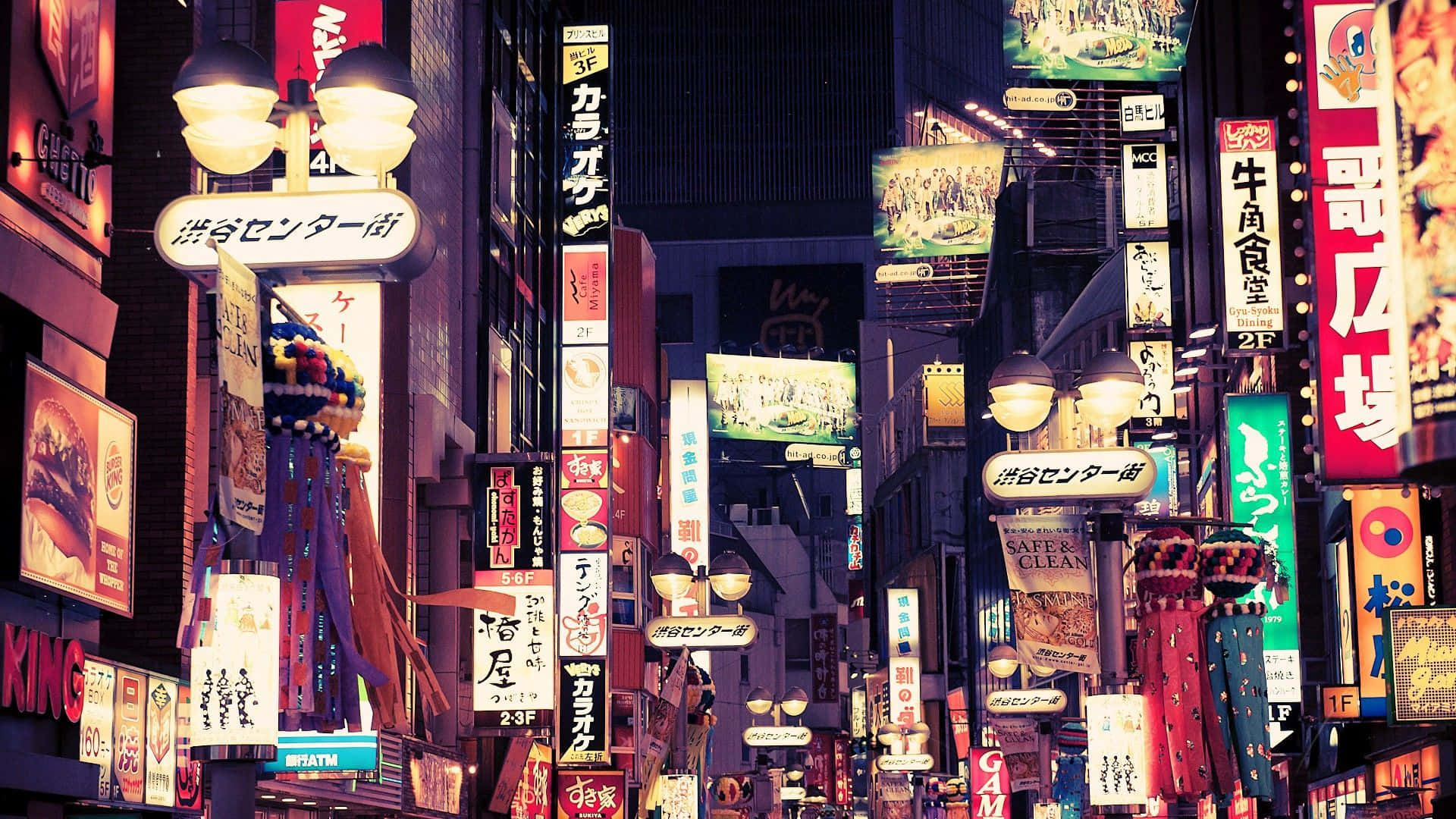 東京 桌布 壁紙 — 充滿活力的霓虹燈和高聳的建築物，在夜晚用色彩繽紛的日本廣告照亮了繁華的東京街道。