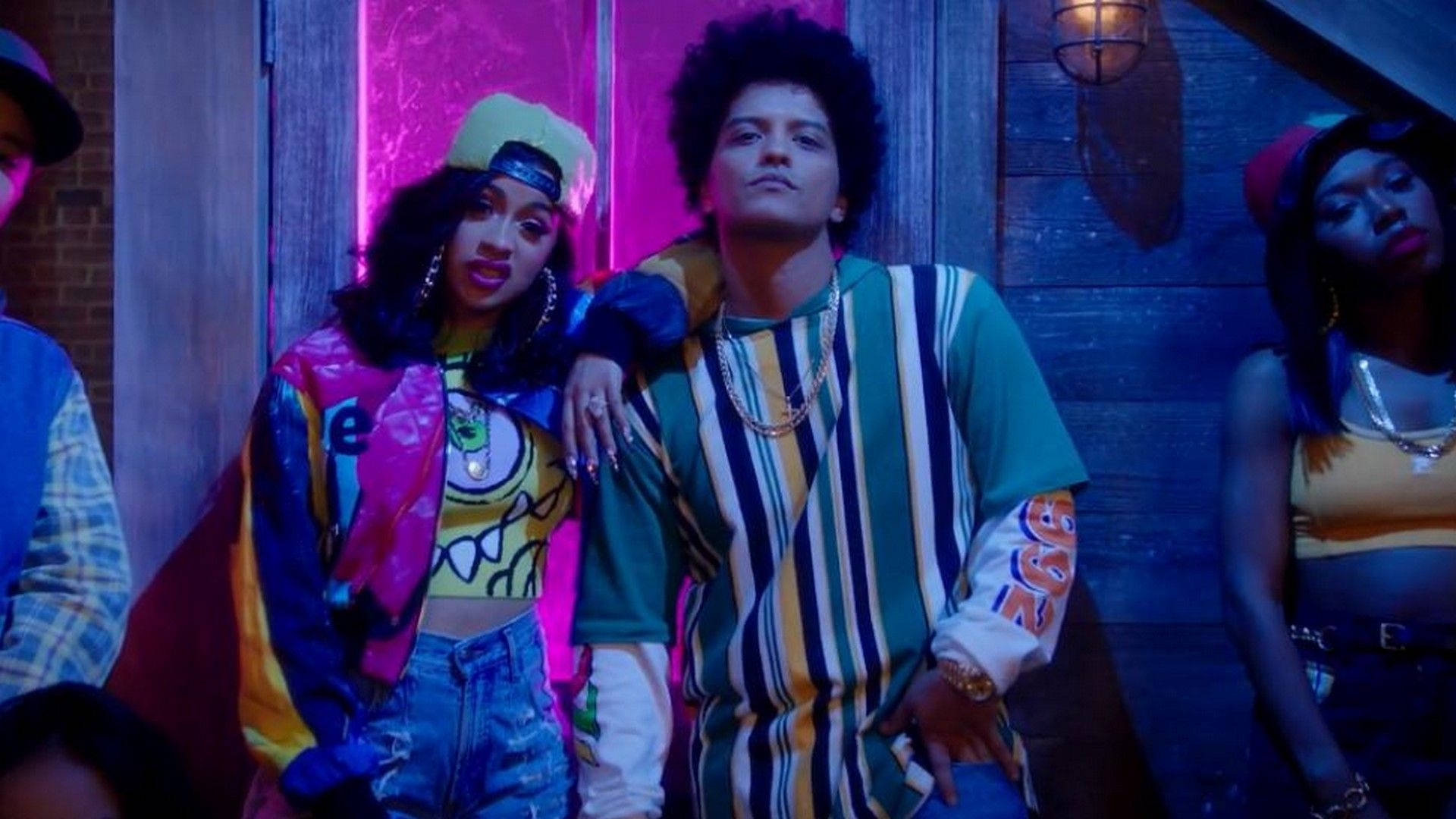 Bruno Mars 桌布 壁紙 — 充滿活力的霓虹燈城市場景，穿著時尚的年輕人自信地在木牆前擺姿勢。
