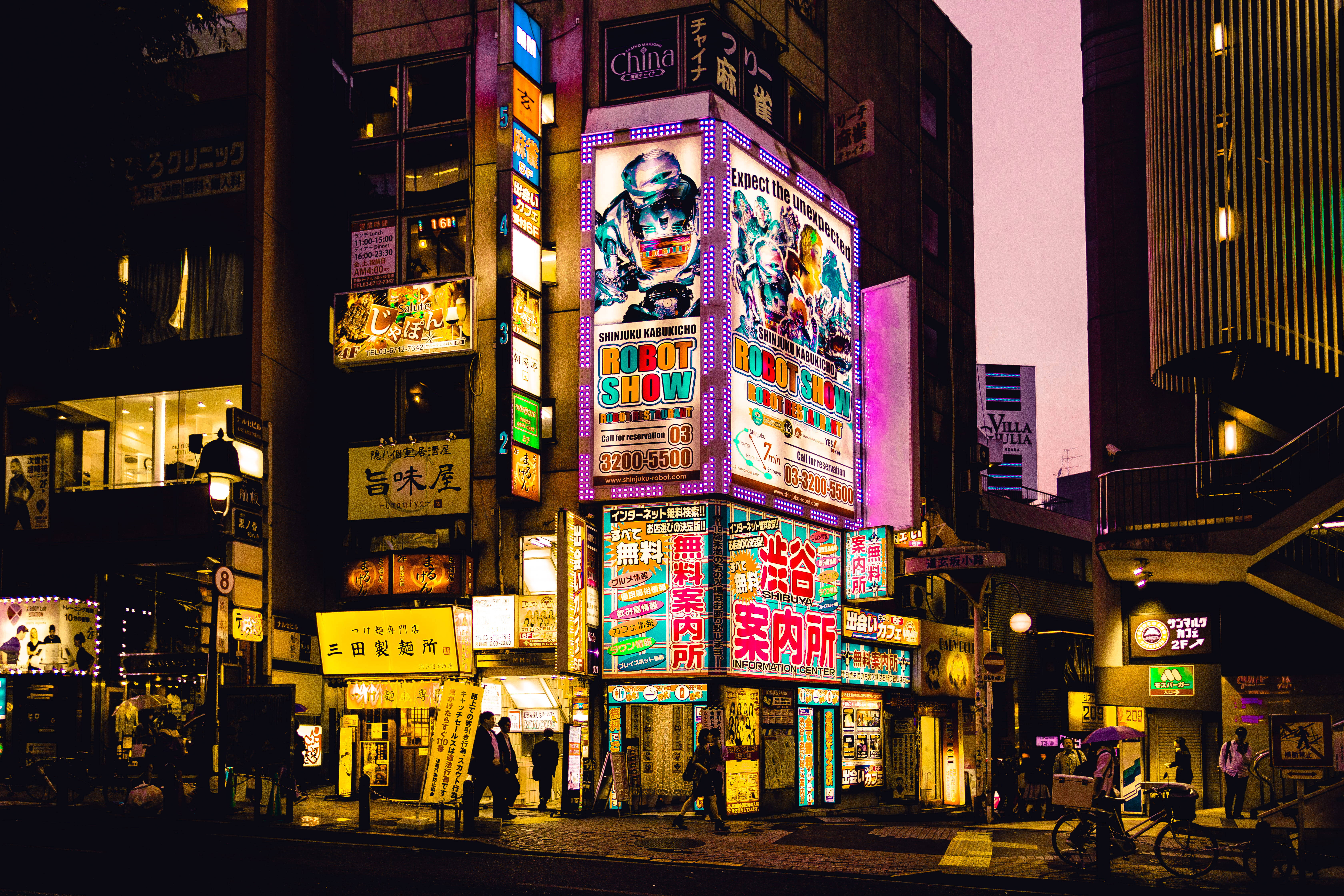 城市 桌布 壁紙 — 充滿活力的霓虹燈招牌在黃昏時照亮了繁忙的東京街道，行人與發光的廣告牌交相輝映。