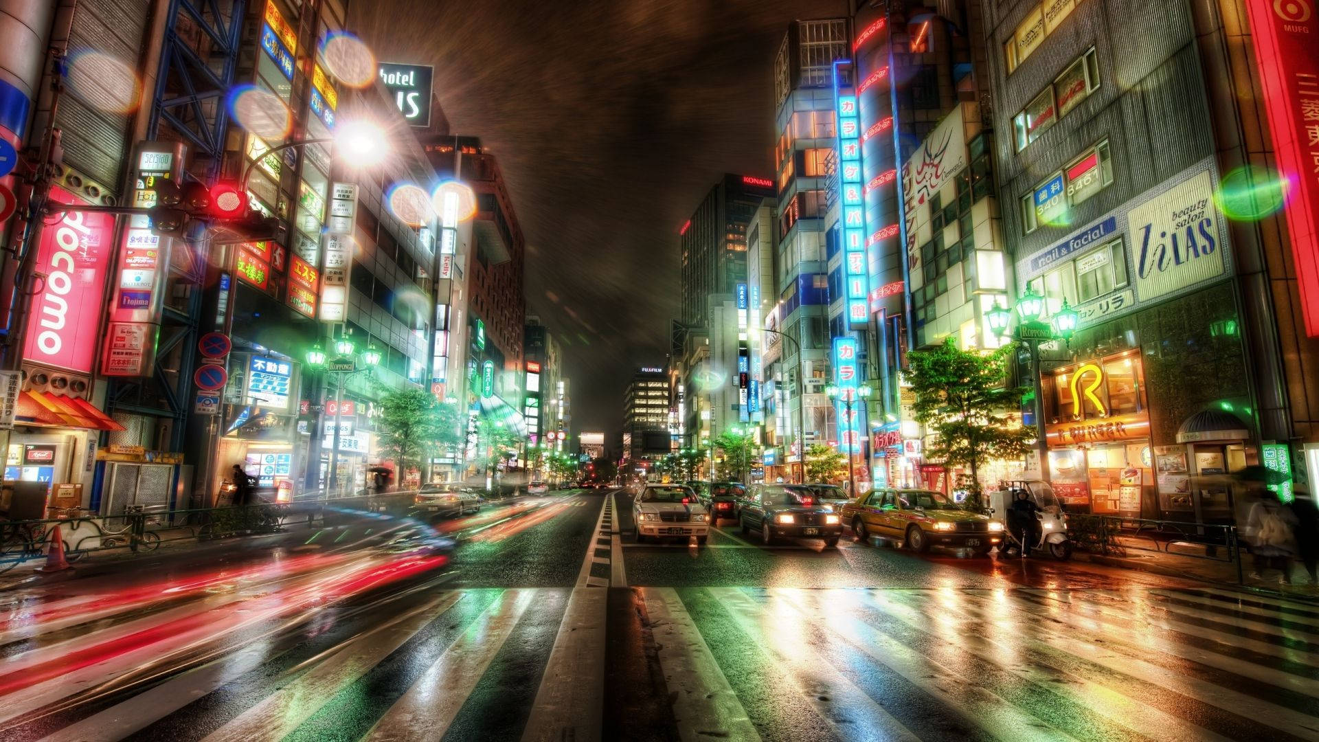 東京 桌布 壁紙 — 充滿活力的霓虹燈東京街道夜景，車燈在濕漉漉的路面上留下光跡。