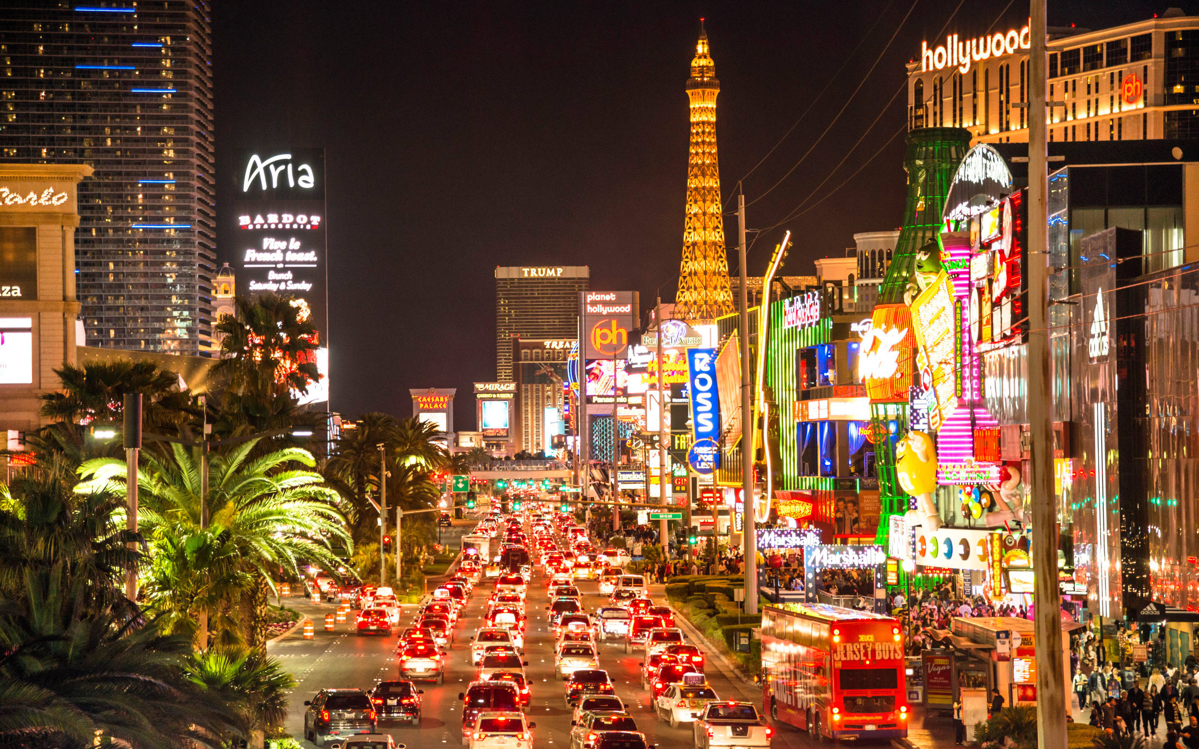 Las Vegas 桌布 壁紙 — 充滿活力的霓虹燈照亮了夜晚繁忙的拉斯維加斯大道，車流和標誌性酒店。