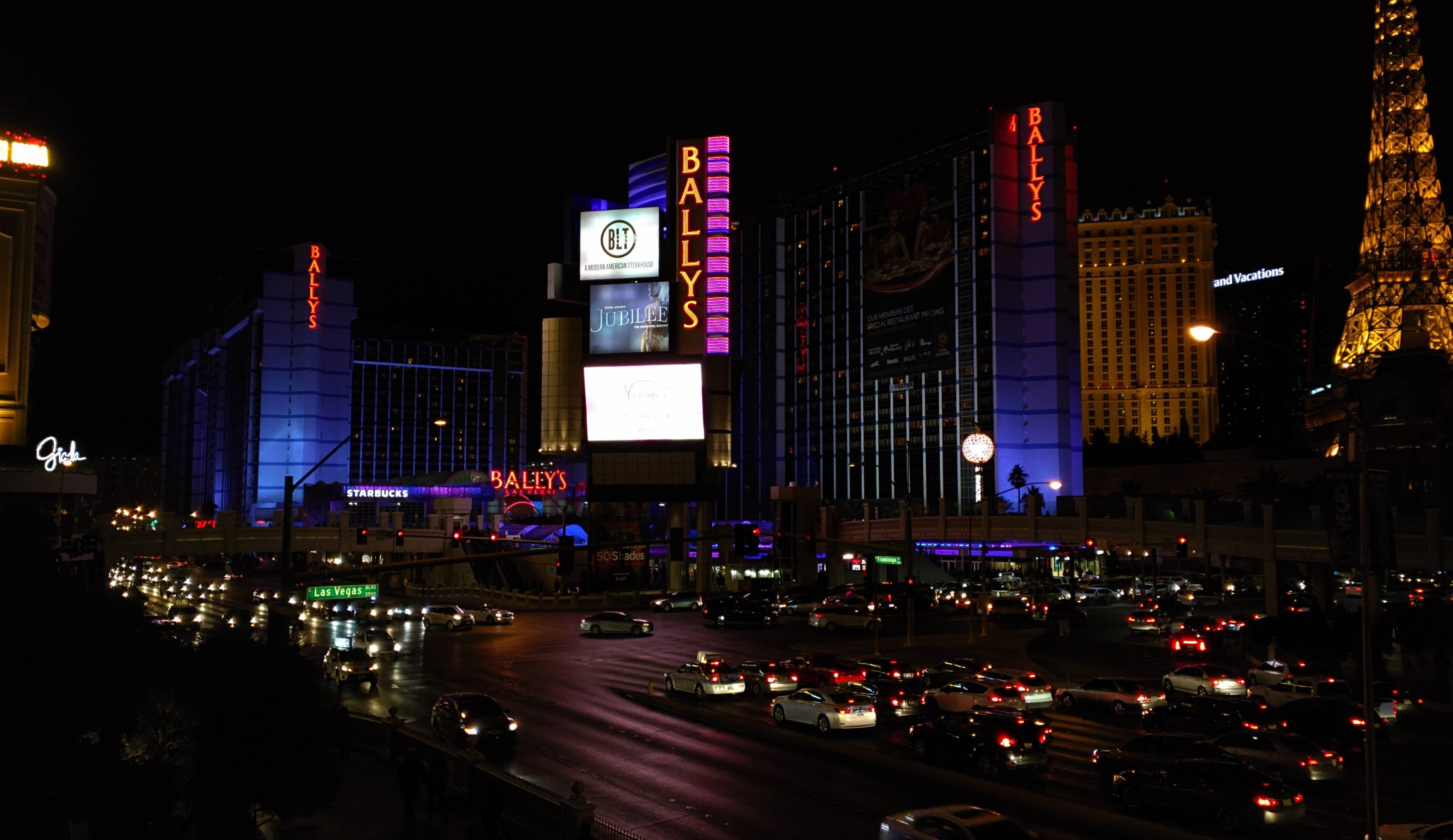 Las Vegas 桌布 壁紙 — 充滿活力的霓虹燈照亮了夜晚繁忙的拉斯維加斯大道，閃爍的賭場招牌和下方繁忙的交通。