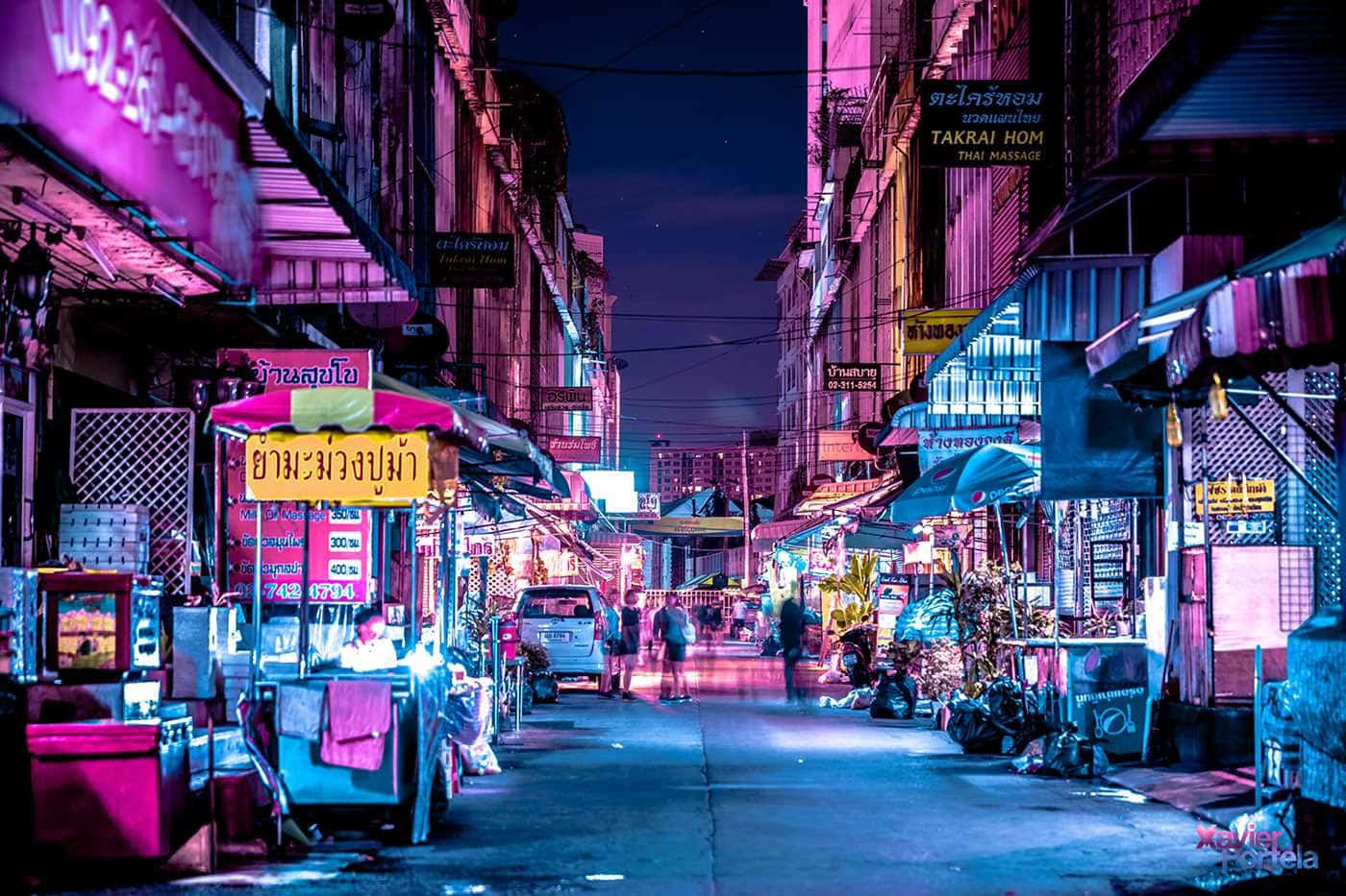 美學 桌布 壁紙 — 充滿活力的霓虹燈照亮了夜晚繁華的泰國小巷，閃爍的招牌和街頭小販。