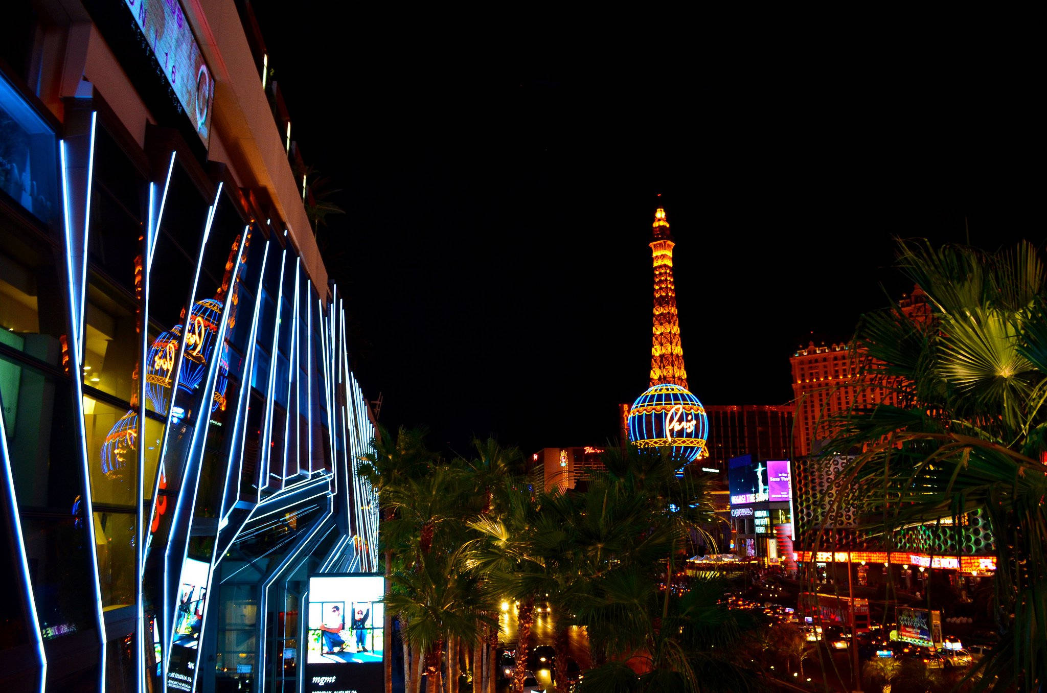 Las Vegas 桌布 壁紙 — 充滿活力的霓虹燈照亮了繁華的拉斯維加斯夜景，艾菲爾鐵塔複製品在黑暗的天空中閃閃發光。