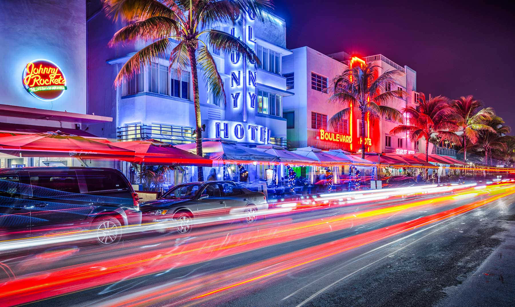 Miami 桌布 壁紙 — 充滿活力的霓虹燈照亮了邁阿密夜晚繁忙的街道，棕櫚樹和汽車燈光劃過。