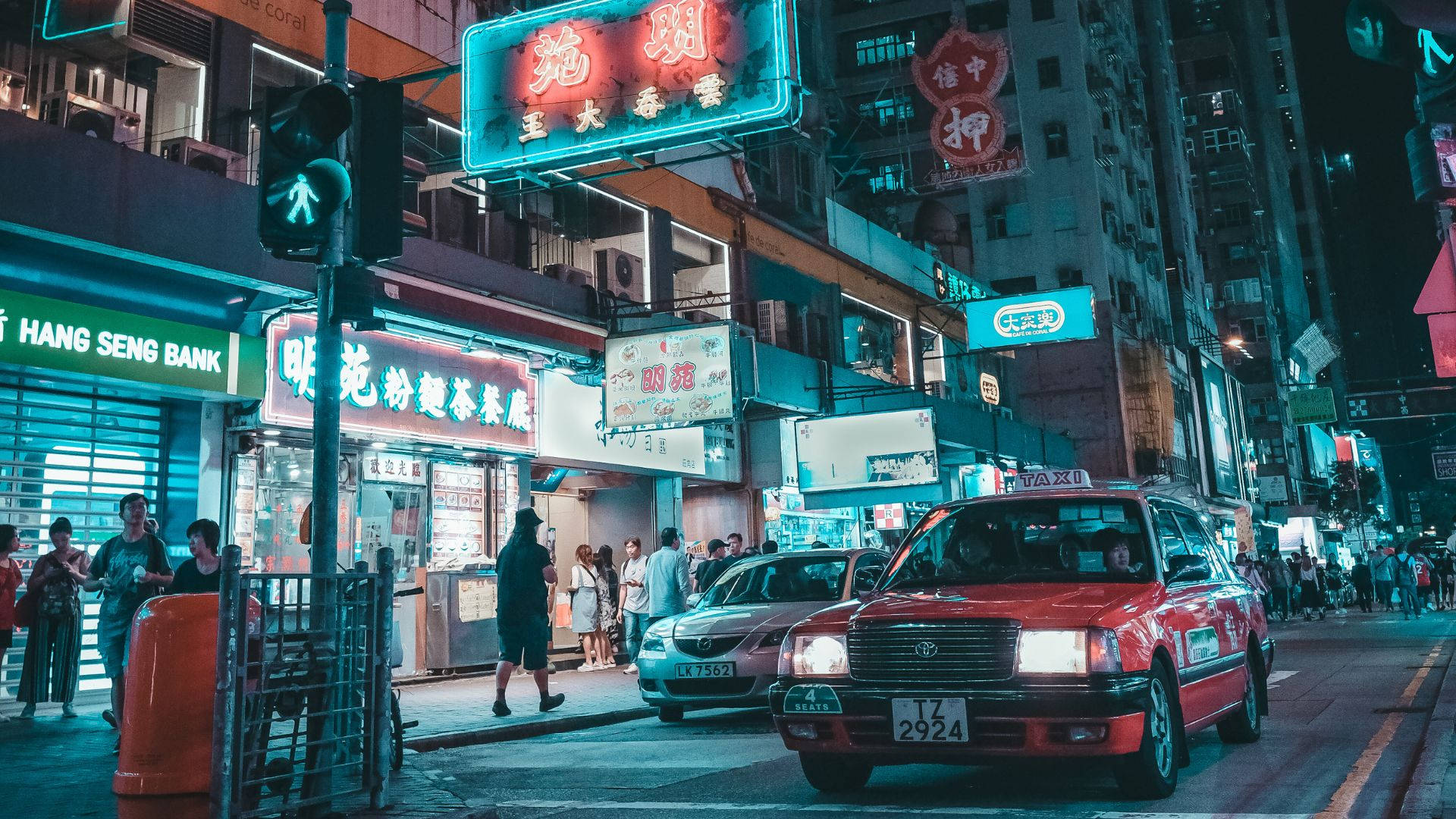 美學 桌布 壁紙 — 充滿活力的霓虹燈照亮了香港夜晚繁忙的街道，行人與紅色計程車穿梭其間。