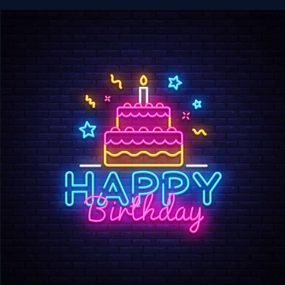 Birthday Cake 桌布 壁紙 — 充滿活力的霓虹燈牌，上面有兩層生日蛋糕和 'Happy Birthday' 文字，在深色磚牆上發光。