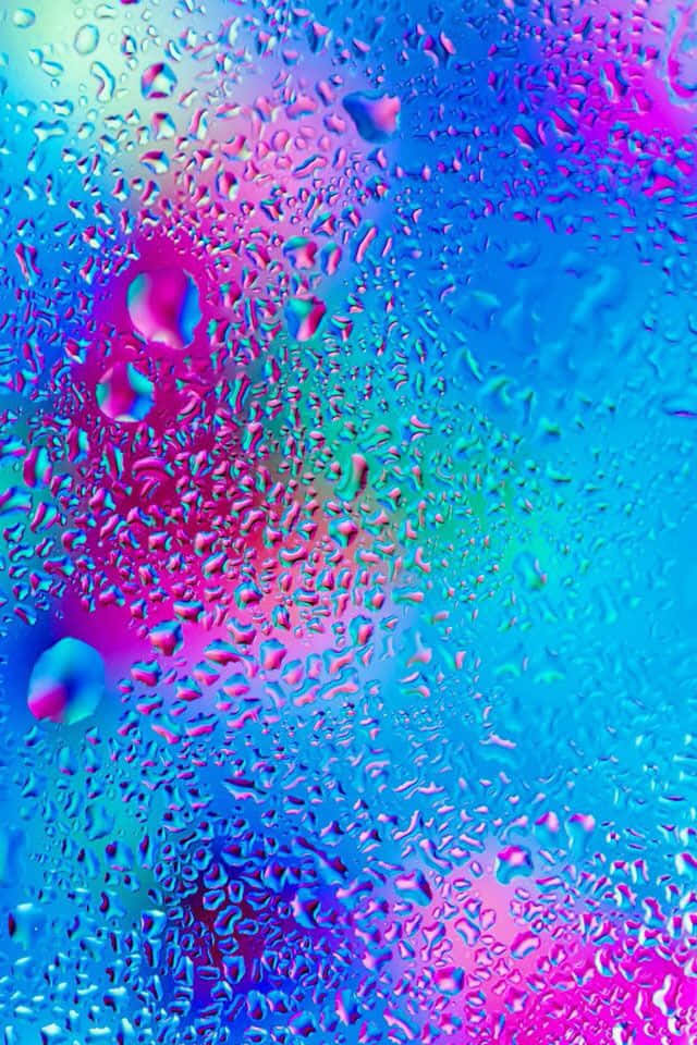 pastel 桌布 壁紙 — 充滿活力的霓虹雨滴在玻璃表面上扭曲了藍色、粉紅色和紫色的萬花筒漸變。