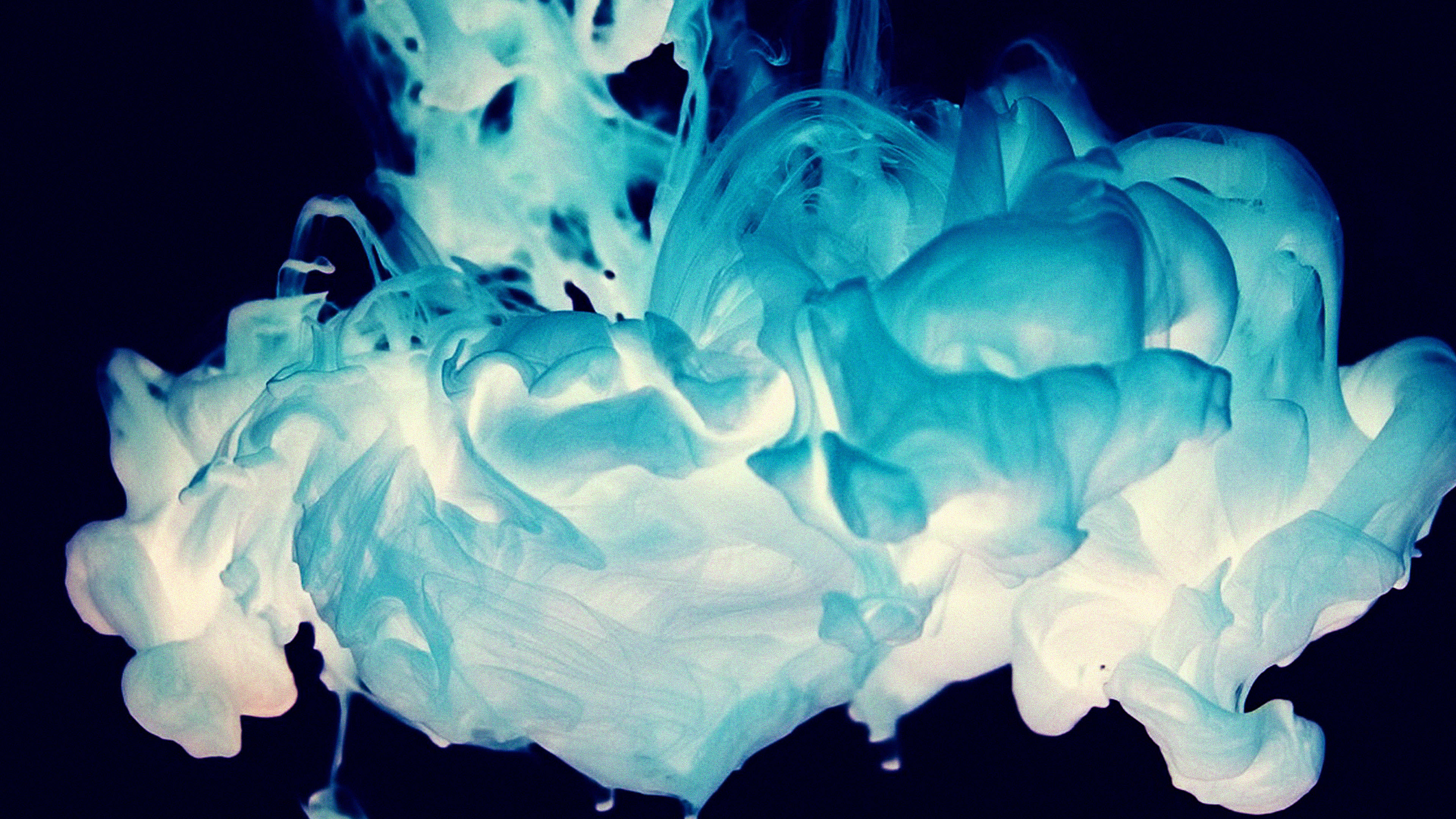 Blue Smoke 桌布 壁紙 — 充滿活力的青色墨水在深黑色背景上動態旋轉，營造出空靈的抽象動感。