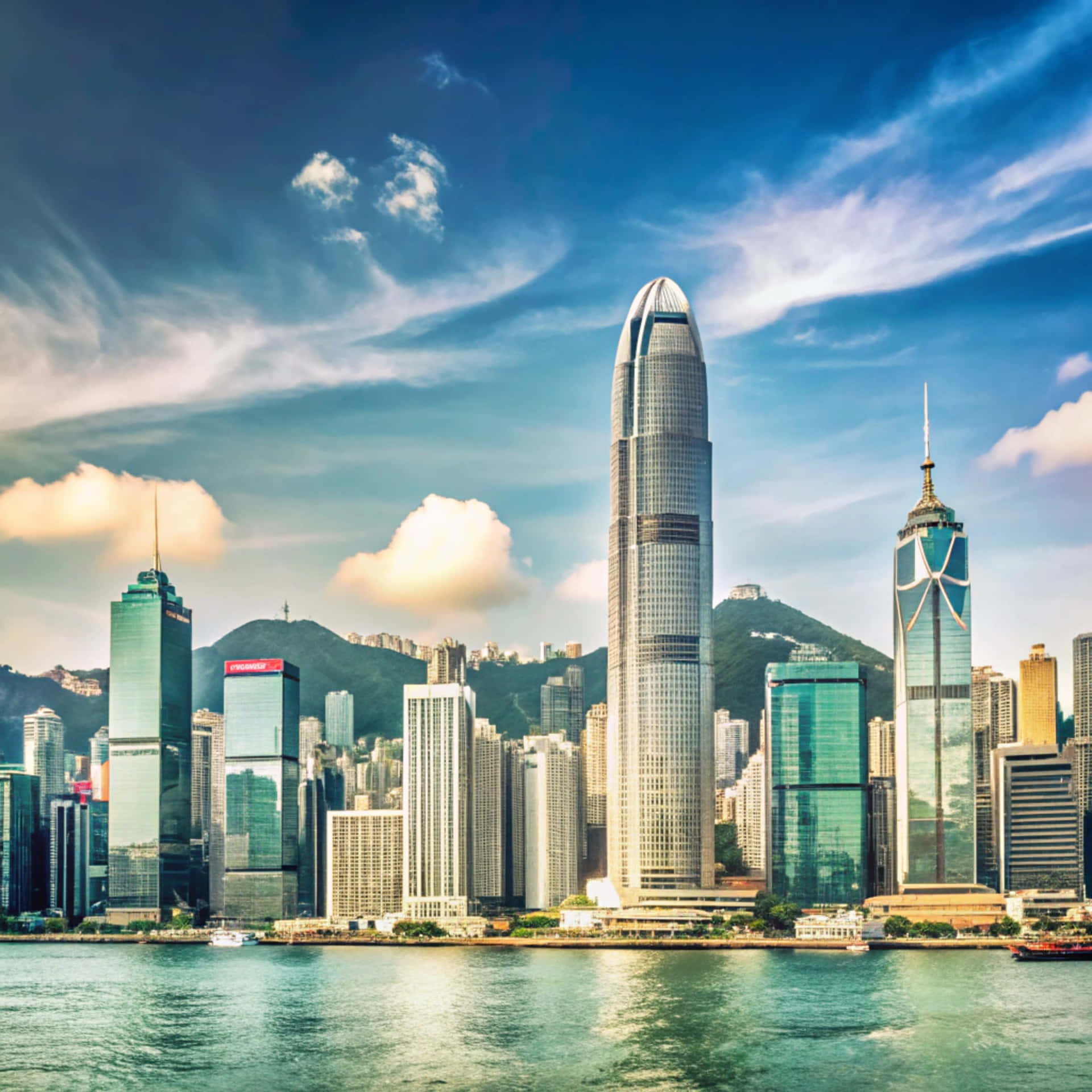 Hong Kong skyline 壁紙 — 充滿活力的香港城市景觀，高聳的摩天大樓在動態的藍天和白雲下反射陽光。