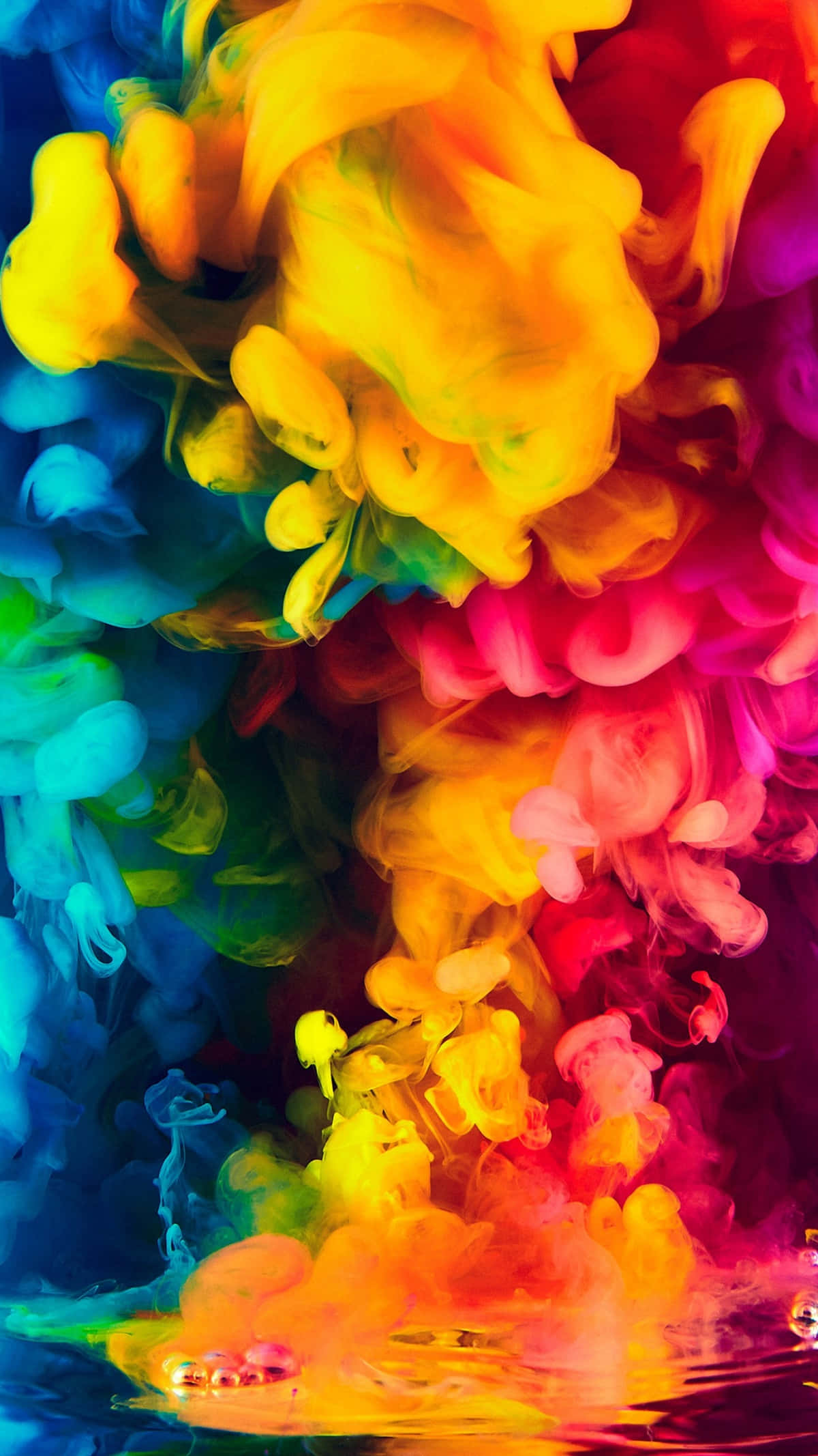 Paint Splash 桌布 壁紙 — 充滿活力的黃、粉紅、藍、綠色漩渦墨水在水中爆炸，營造出迷幻的抽象爆發效果。