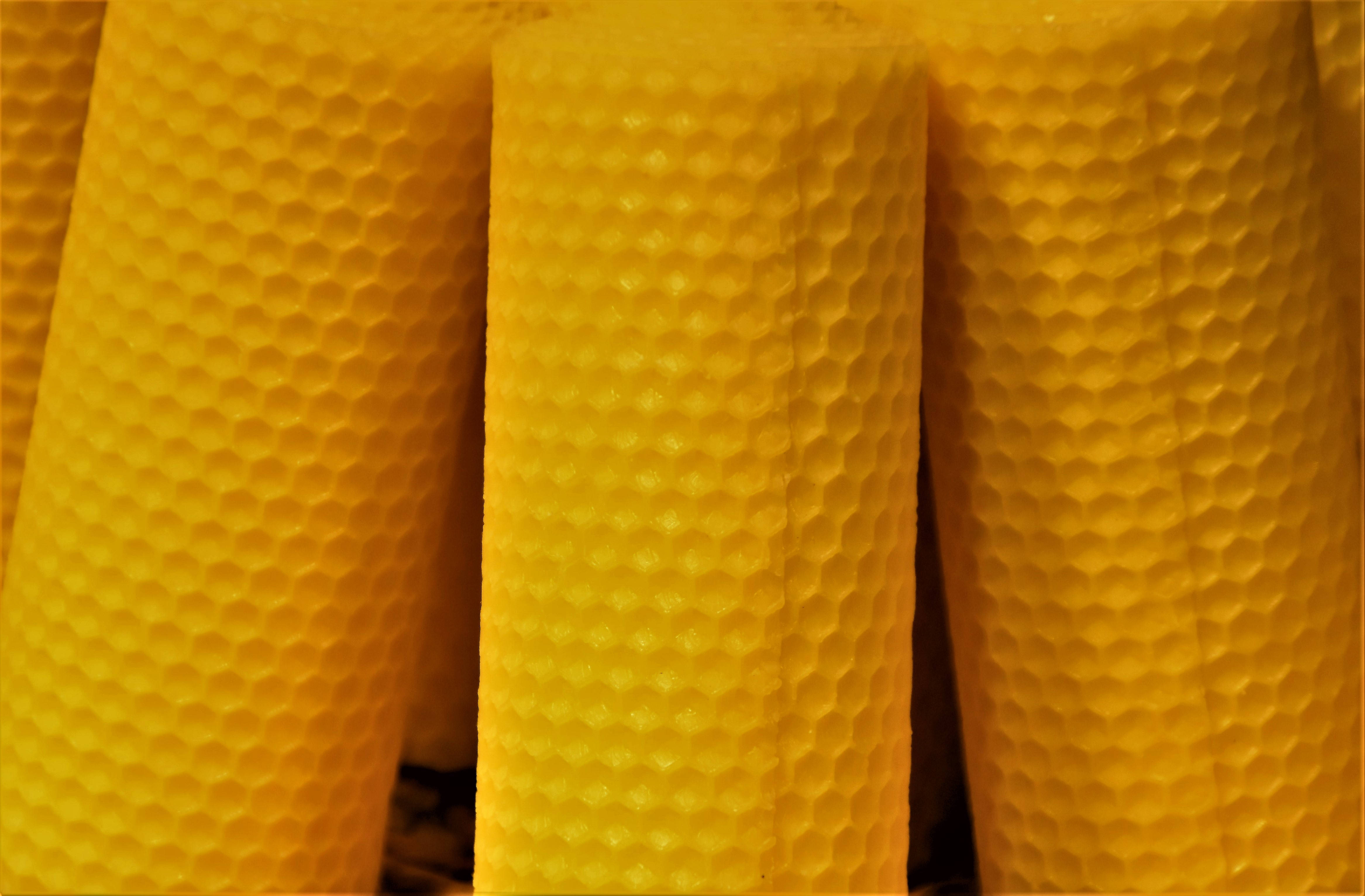 Honeycomb 桌布 壁紙 — 充滿活力的黃色圓柱形蠟梳特寫，帶有六角形圖案，溫暖地發光。