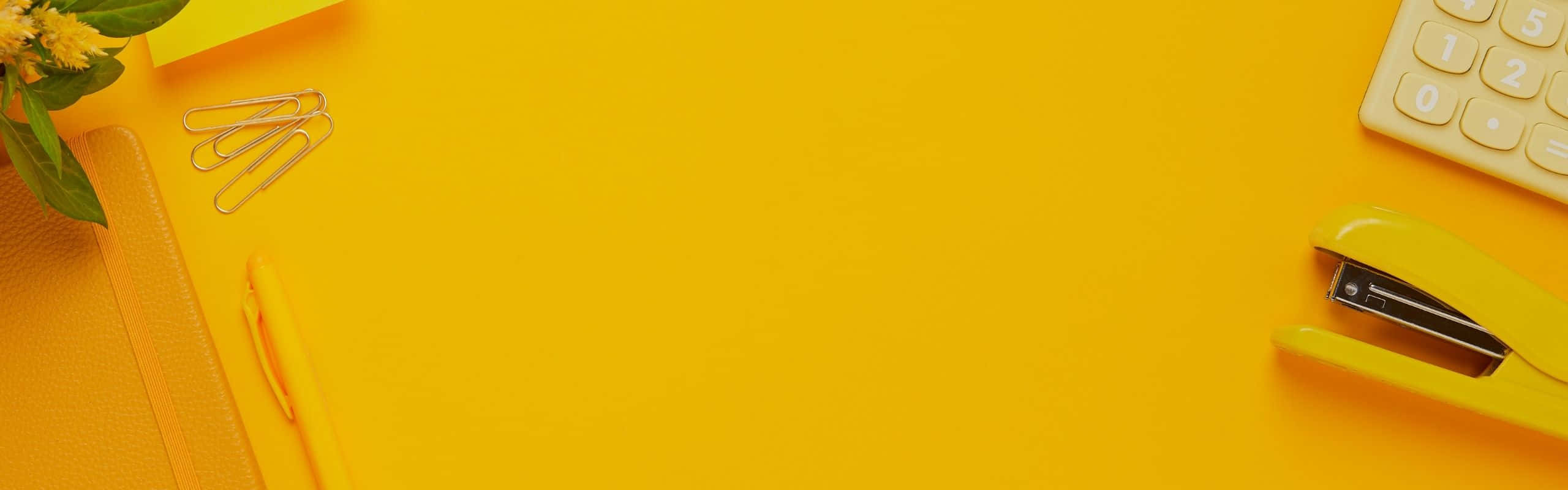 2560x800 桌布 壁紙 — 充滿活力的黃色桌面俯視圖，搭配辦公用品和花朵，以極簡平鋪構圖呈現。