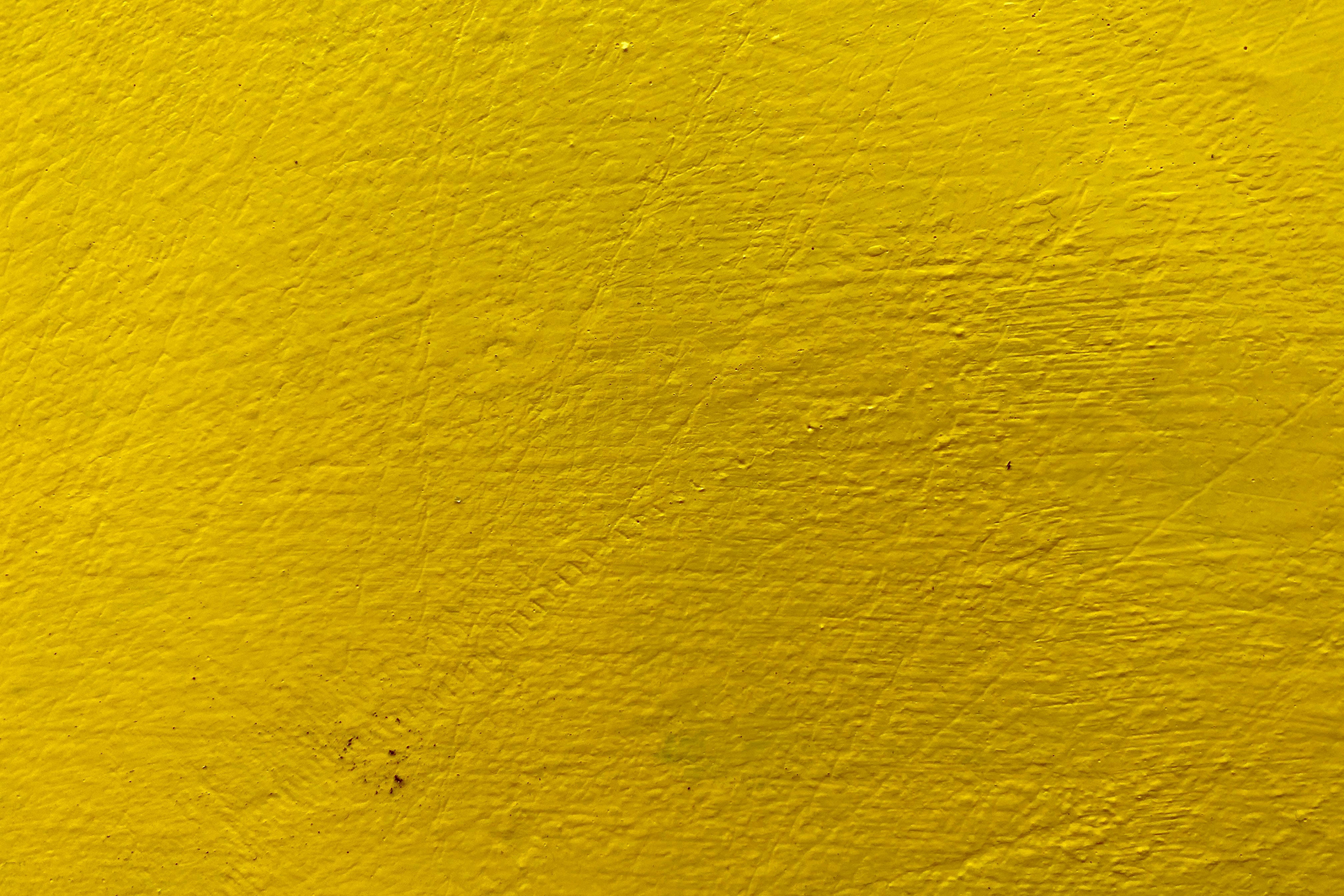 Yellow HD 桌布 壁紙 — 充滿活力的黃色油漆牆壁，帶有紋理筆觸和細微瑕疵。