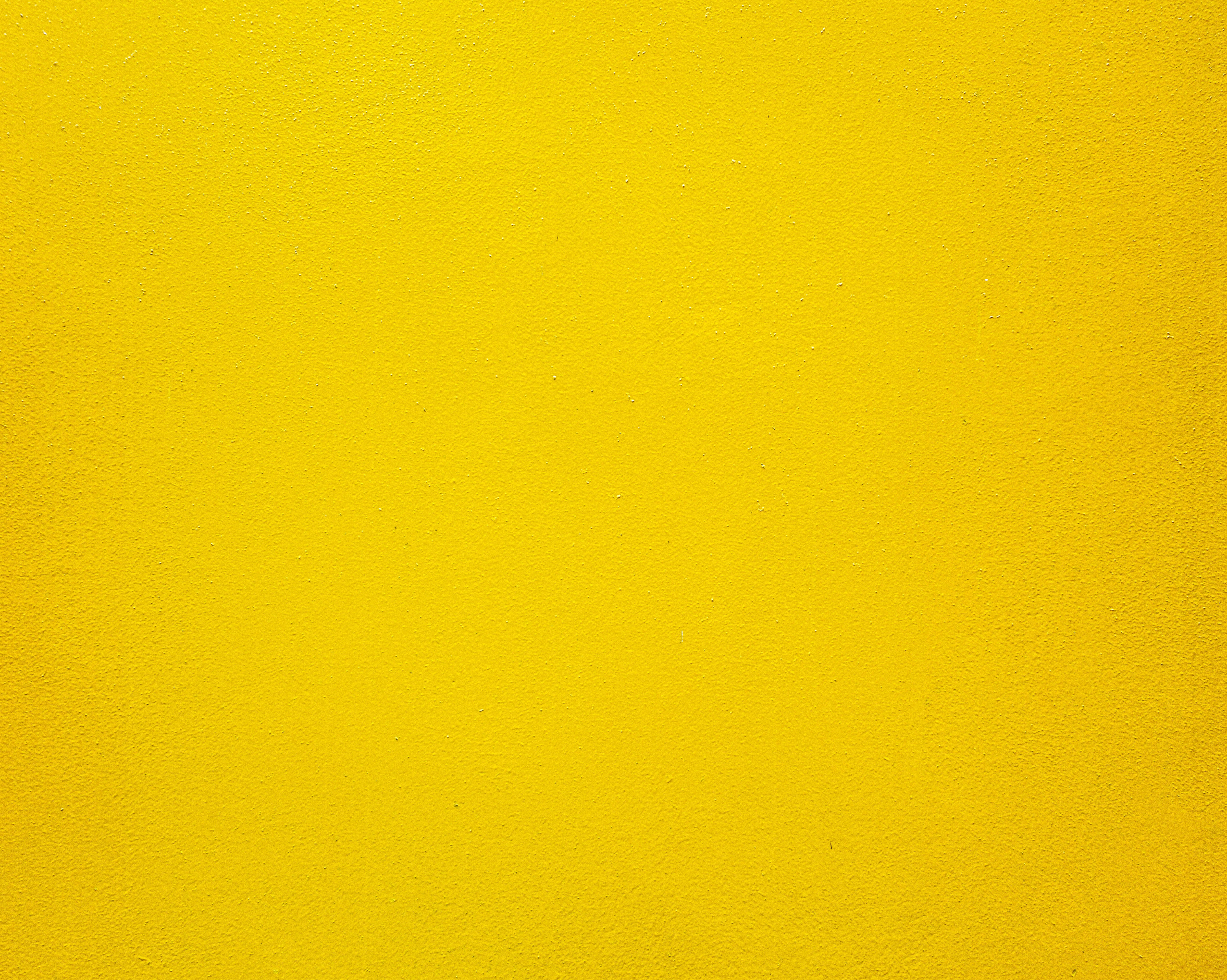 the yellow 桌布 壁紙 — 充滿活力的黃色紋理牆壁，帶有細微顆粒和均勻照明，營造出大膽的極簡背景。