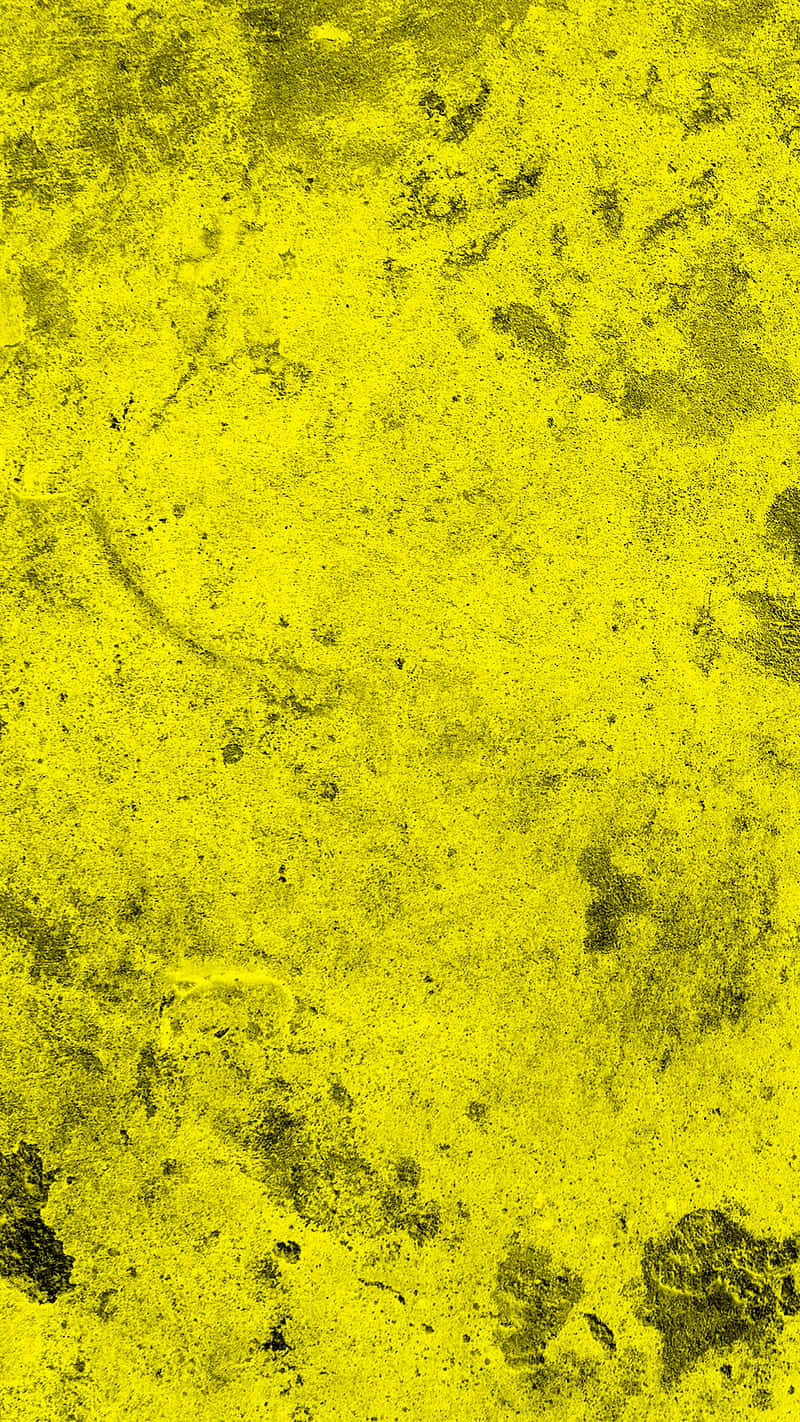 Yellow Grunge 桌布 壁紙 — 充滿活力的黃色紋理表面，帶有深色斑點和磨損區域，形成粗糙的抽象圖案。