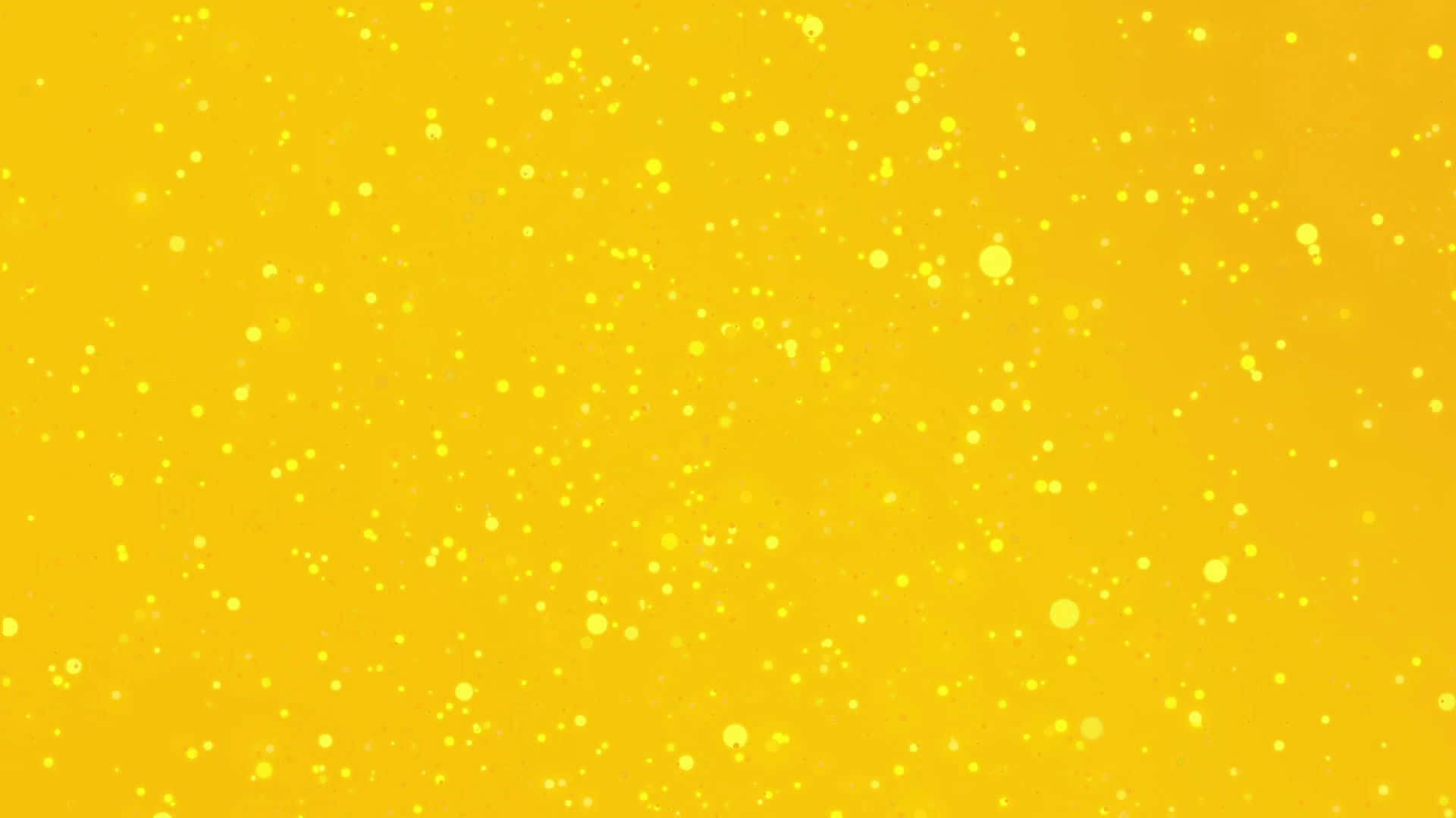 Aesthetic Yellow 桌布 壁紙 — 充滿活力的黃色背景，散落著發光的斑點，營造出閃爍的抽象效果。