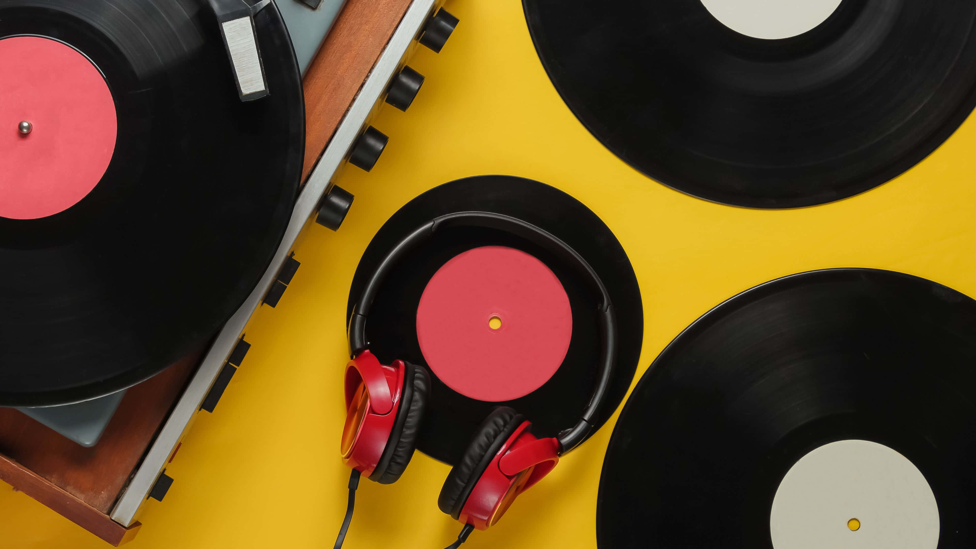record 桌布 壁紙 — 充滿活力的黃色背景，黑色黑膠唱片和紅色耳機圍繞著復古唱盤排列。