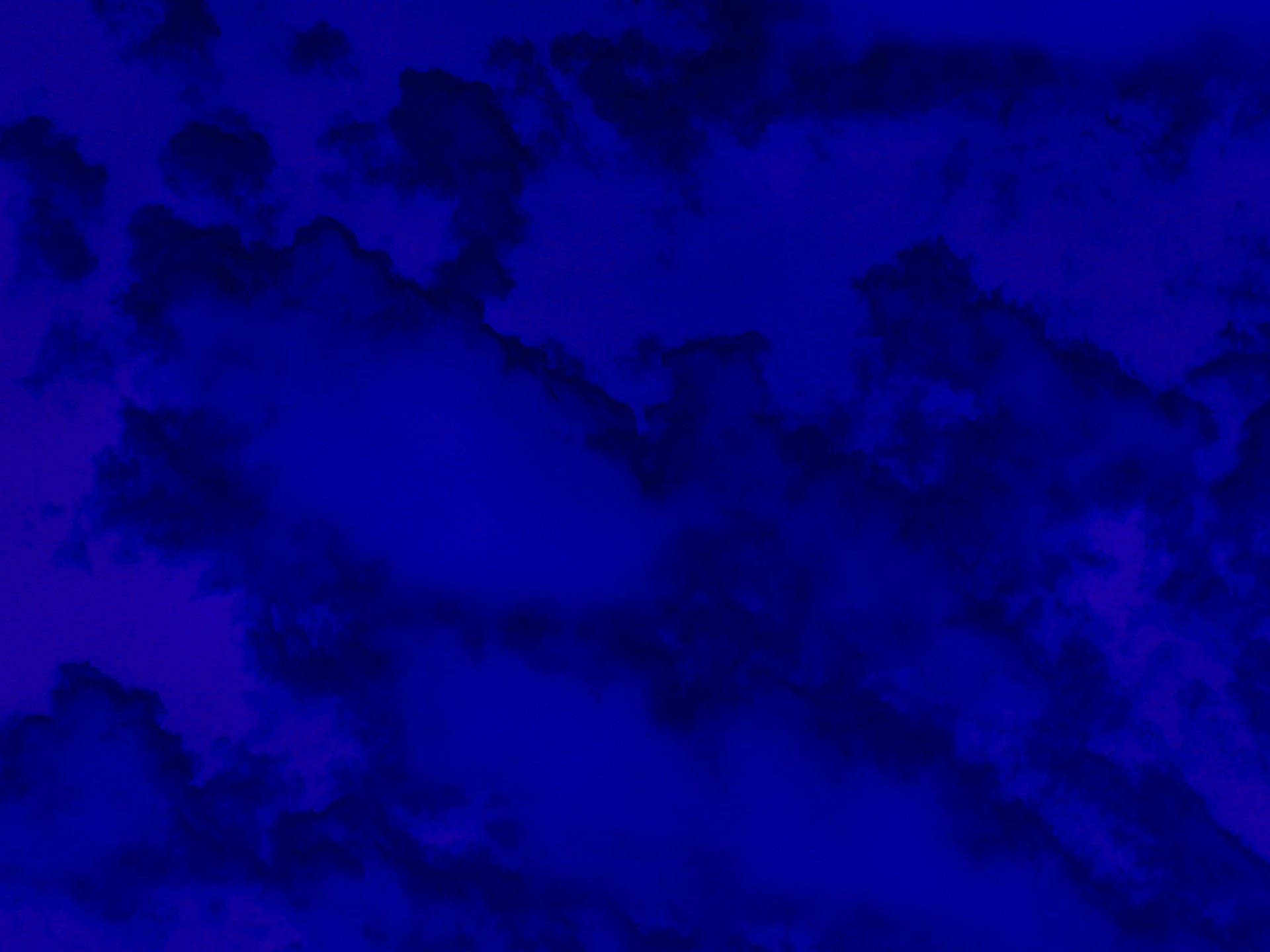 Blue Aesthetic Desktop 桌布 壁紙 — 充滿漩渦狀深藍色和紫色雲朵的陰鬱天空，營造出戲劇性的大氣效果。
