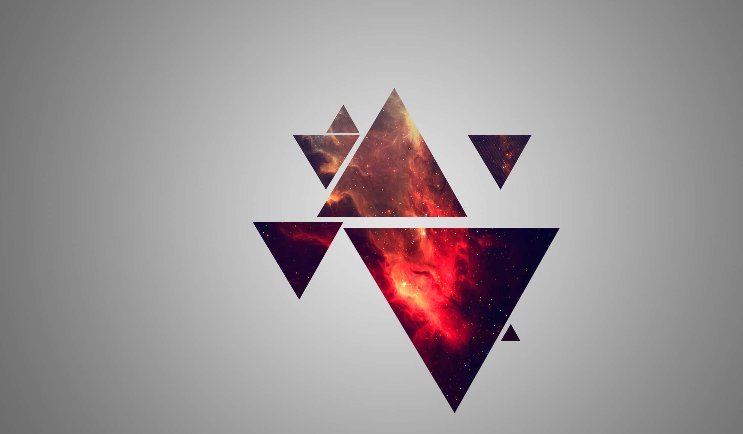 Indie Desktop 桌布 壁紙 — 充滿熾熱星雲的幾何三角形在柔和的灰色漸變背景上發光。