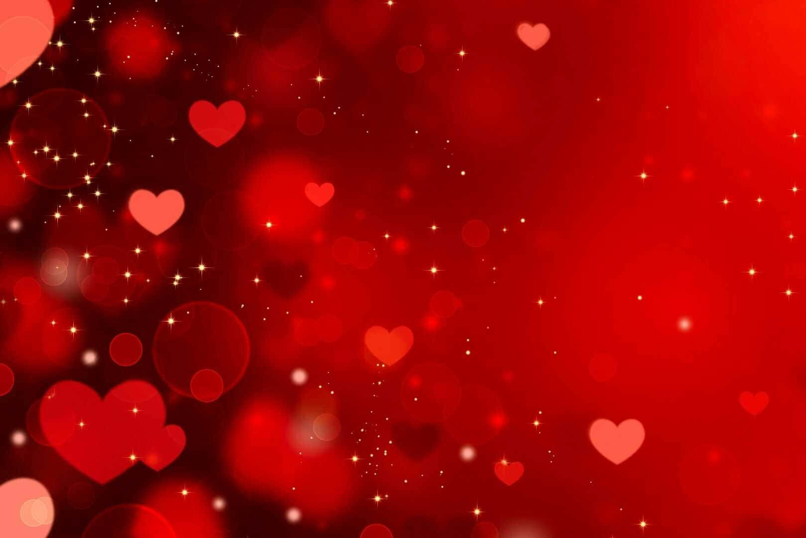 Happy Valentines Day 桌布 壁紙 — 充滿發光心形和閃爍星星的鮮豔紅色背景，營造出浪漫神奇的氛圍。