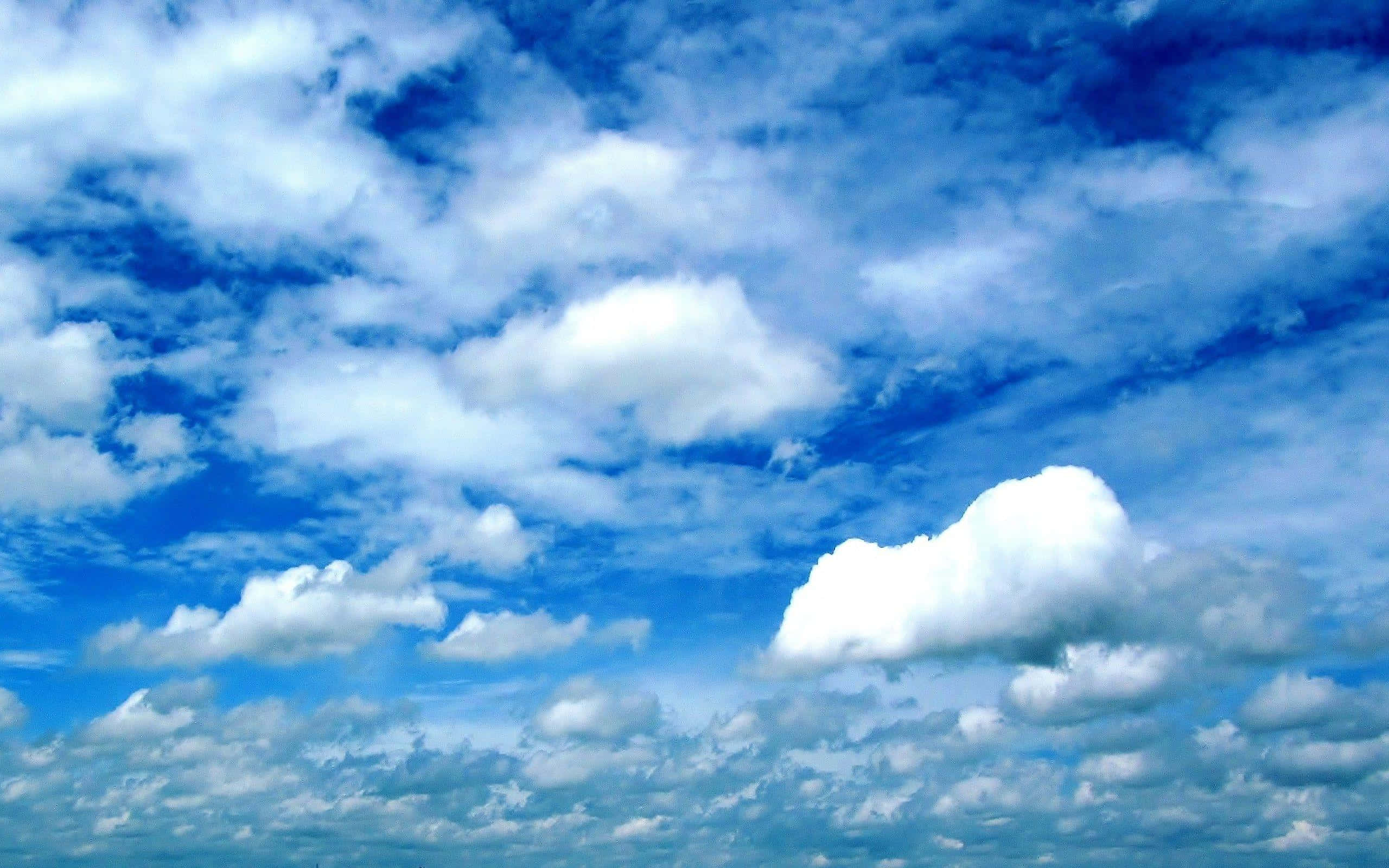 Sky Clouds 桌布 壁紙 — 充滿蓬鬆白雲的鮮豔藍天，在明亮的白天地平線上飄移。
