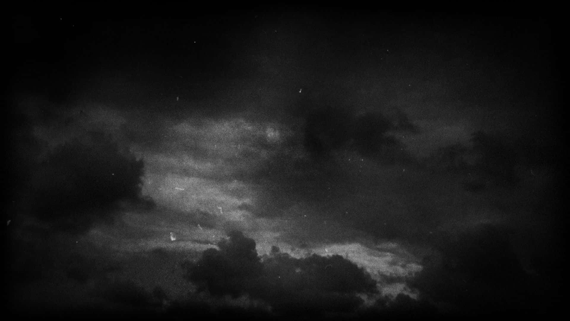 Dark Grey Aesthetic 桌布 壁紙 — 充滿質感雲層和微弱星光的黑白夜空，星光透過黑暗的縫隙隱約可見。