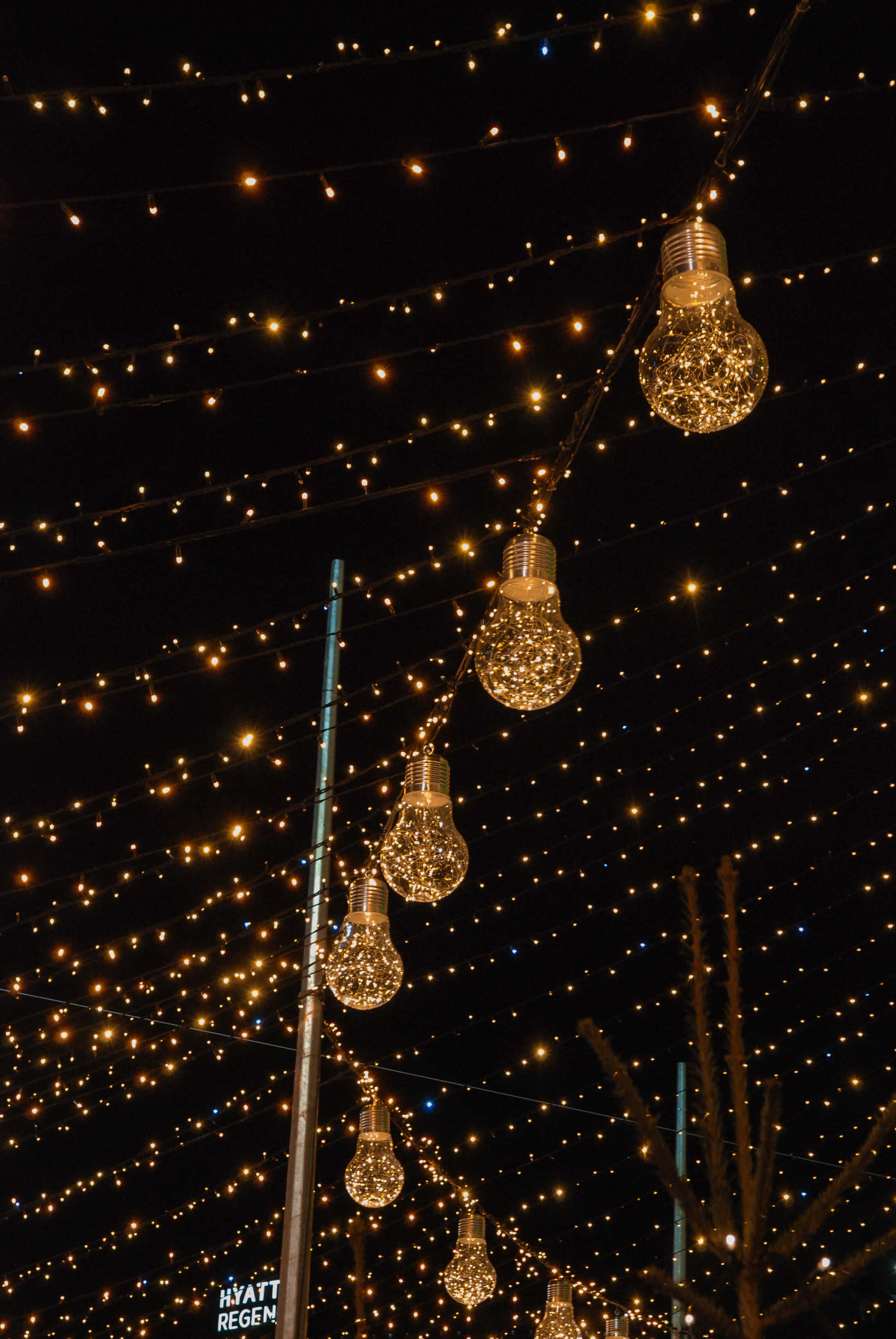 lights 桌布 壁紙 — 充滿金色亮粉的燈泡和溫暖的仙女燈串在漆黑的夜空中閃爍。