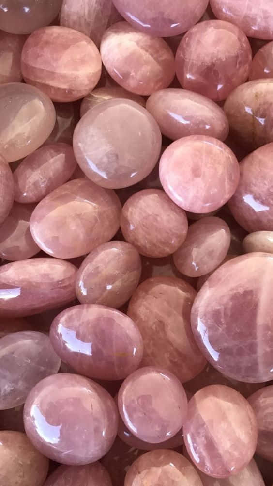 Rose Gold Color 桌布 壁紙 — 光滑拋光玫瑰石英石的近距離特寫，呈現柔和粉紅色調，帶有天然紋理和光澤反射。