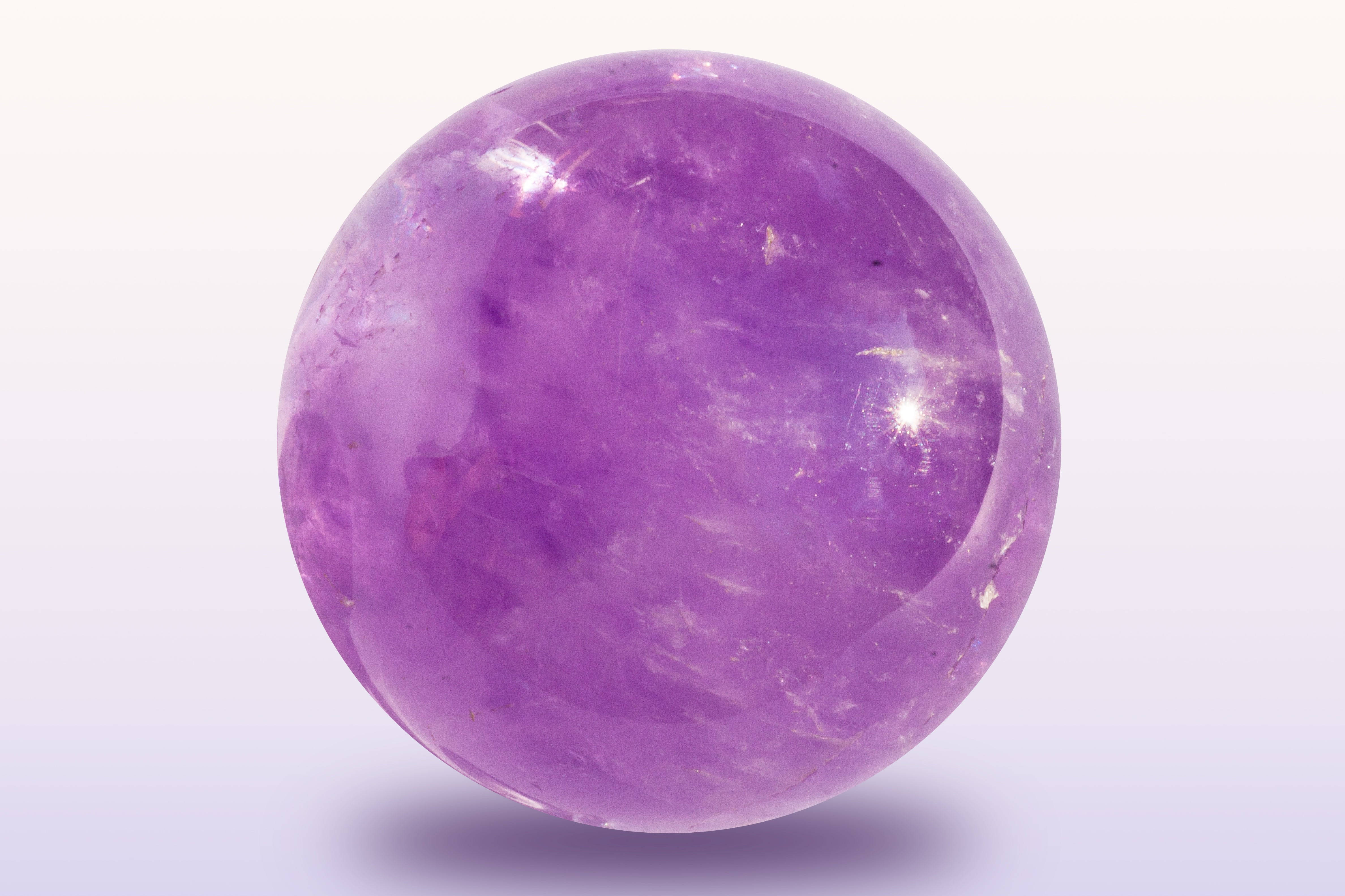 紫水晶 桌布 壁紙 — 光滑拋光的紫色紫水晶球體在柔和漸變背景上閃耀著內部裂紋。