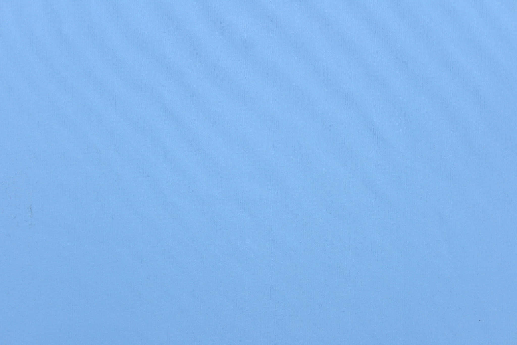 Solid Light Blue 桌布 壁紙 — 光滑淺藍色布料表面，帶有細微紋理和輕微瑕疵。