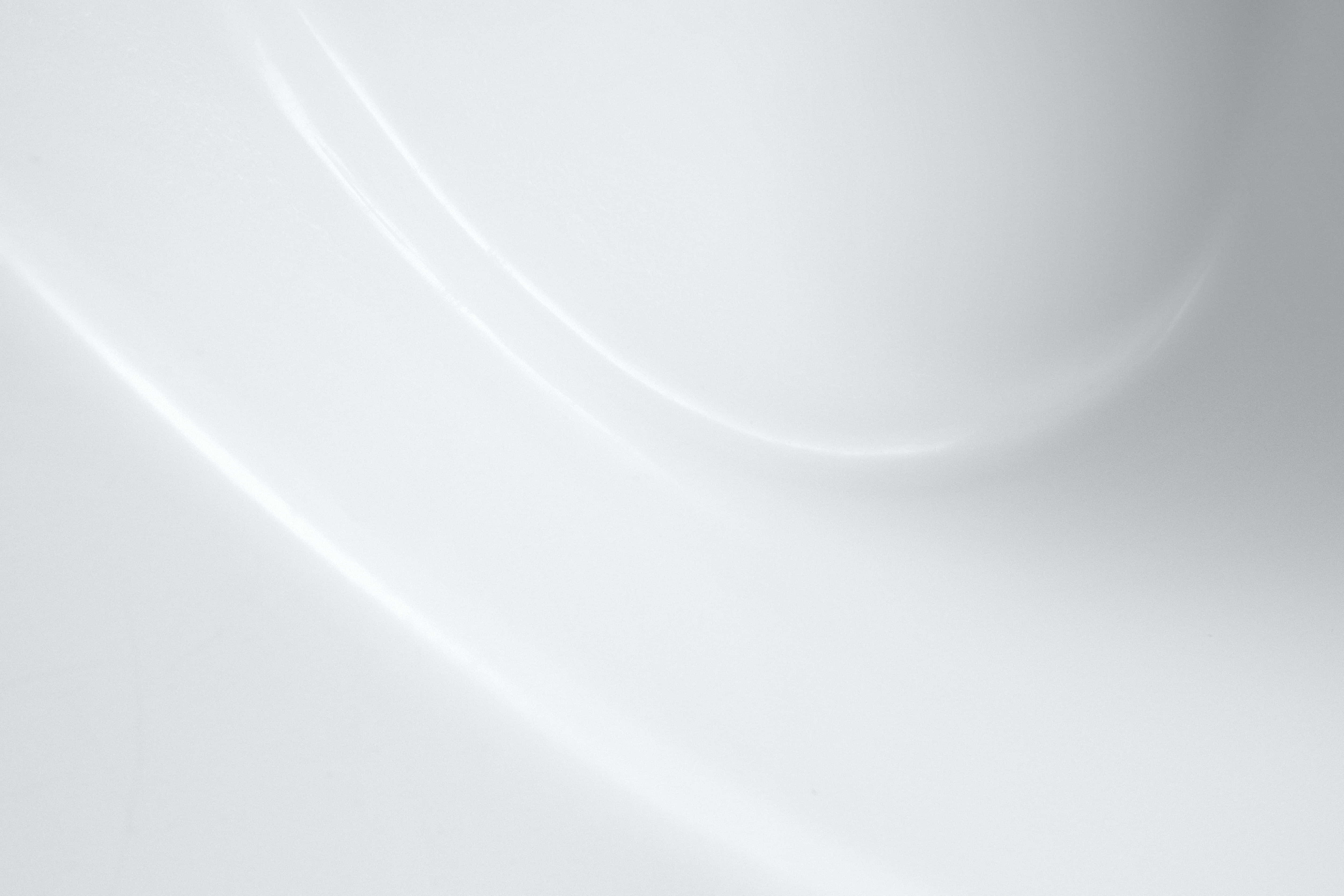 Abstract Design 桌布 壁紙 — 光滑白色布料，帶有柔和彎曲的皺褶和溫和的高光，營造出極簡寧靜的質感。