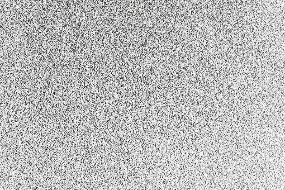 White Texture 桌布 壁紙 — 光滑白色灰泥牆的特寫，帶有細微紋理和均勻照明。