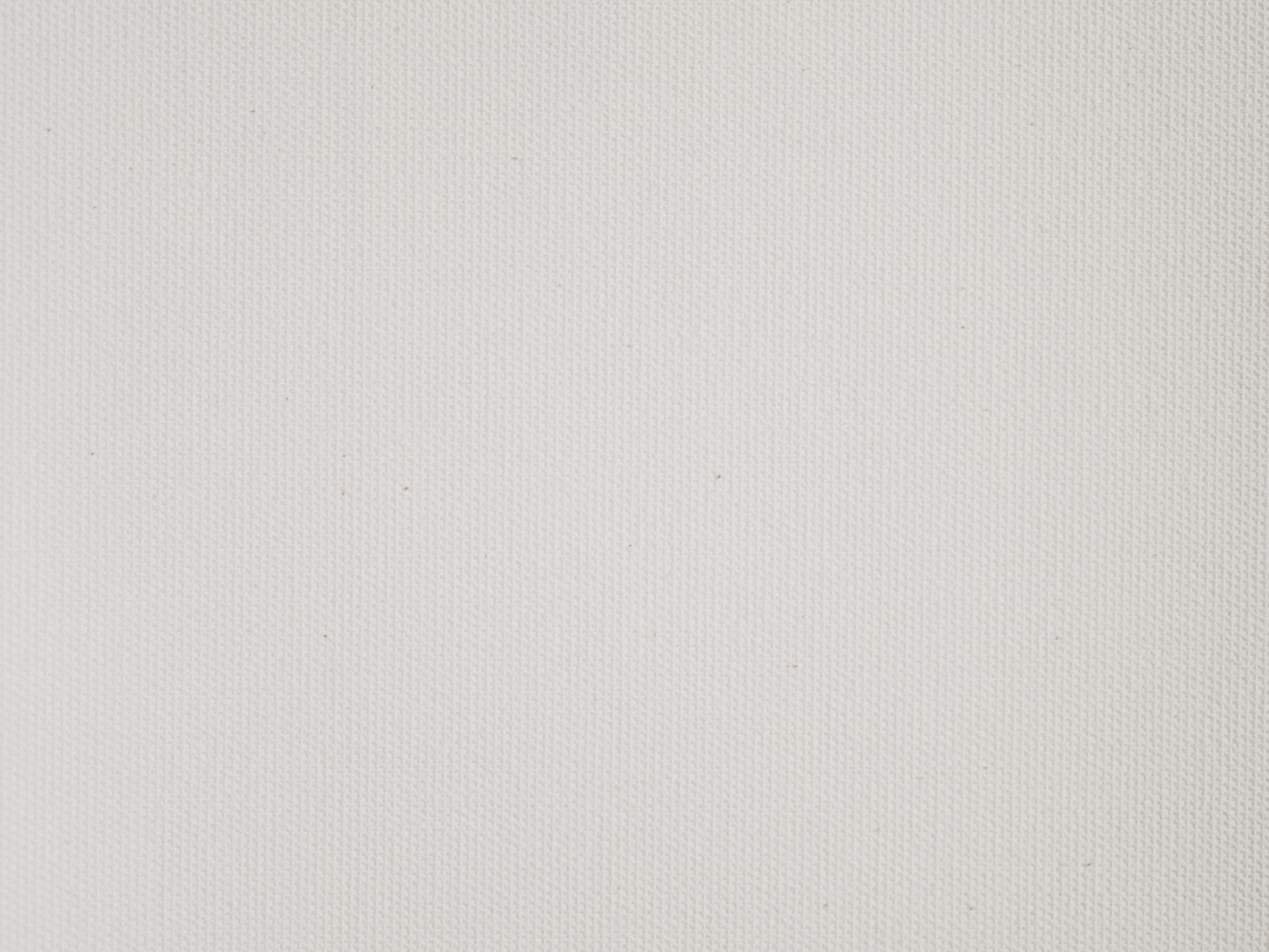 Textured 桌布 壁紙 — 光滑白色畫布表面的特寫，帶有微妙的編織紋理和微弱的灰塵斑點。