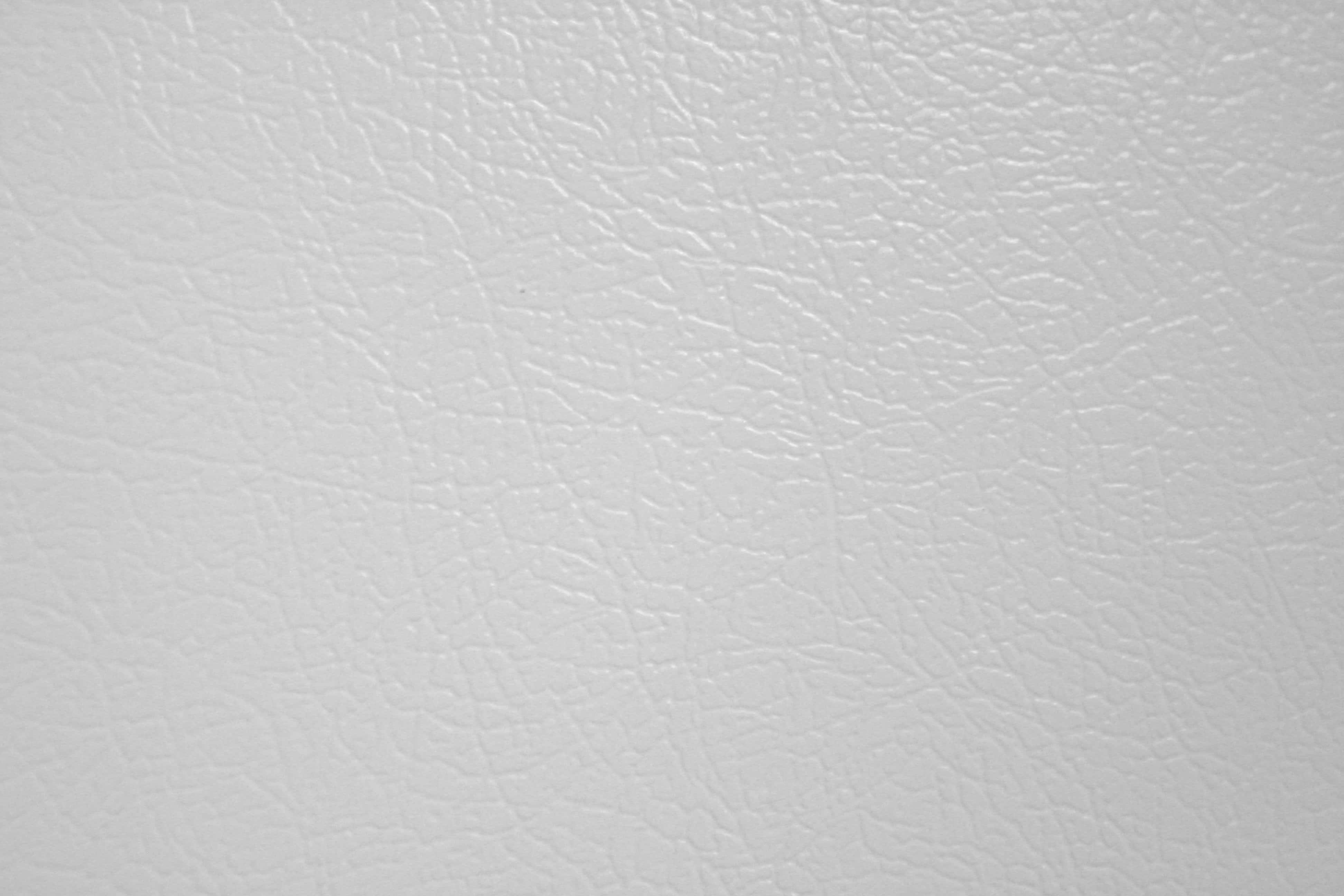 texture 桌布 壁紙 — 光滑白色皮革紋理的近距離特寫，帶有微妙的自然皺褶和柔和光線。