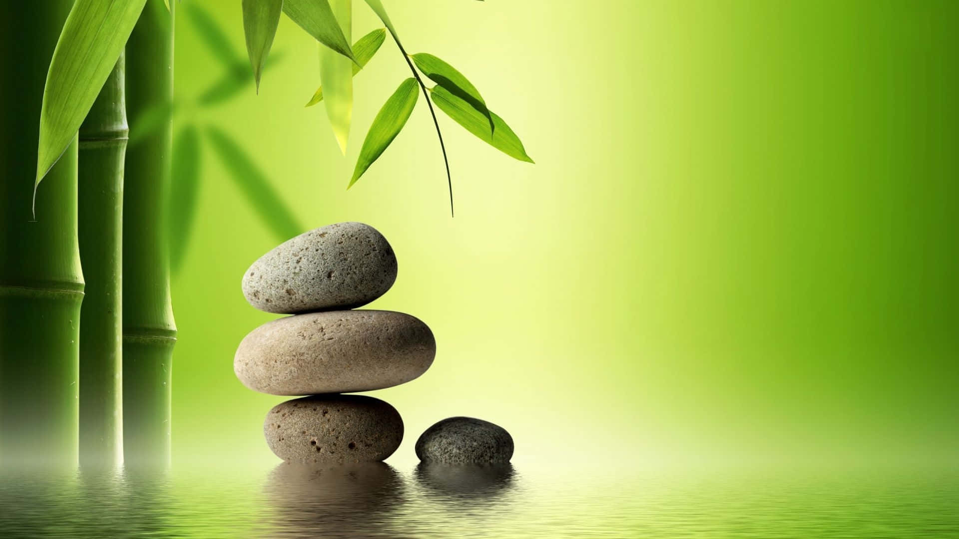 禪 桌布 壁紙 — 光滑的石頭堆疊在平靜的水面上，旁邊有竹莖，在柔和的綠光下。