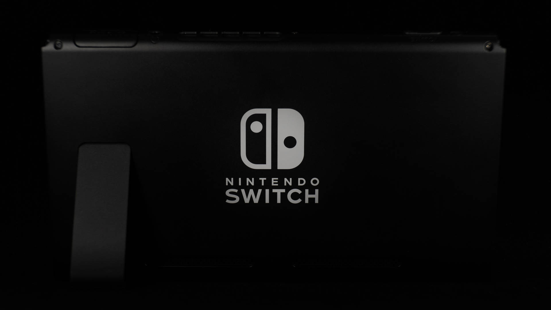 黑色Nintendo Switch主機在黑暗環境中帶有發光標誌 — 任天堂Switch 動圖 壁紙