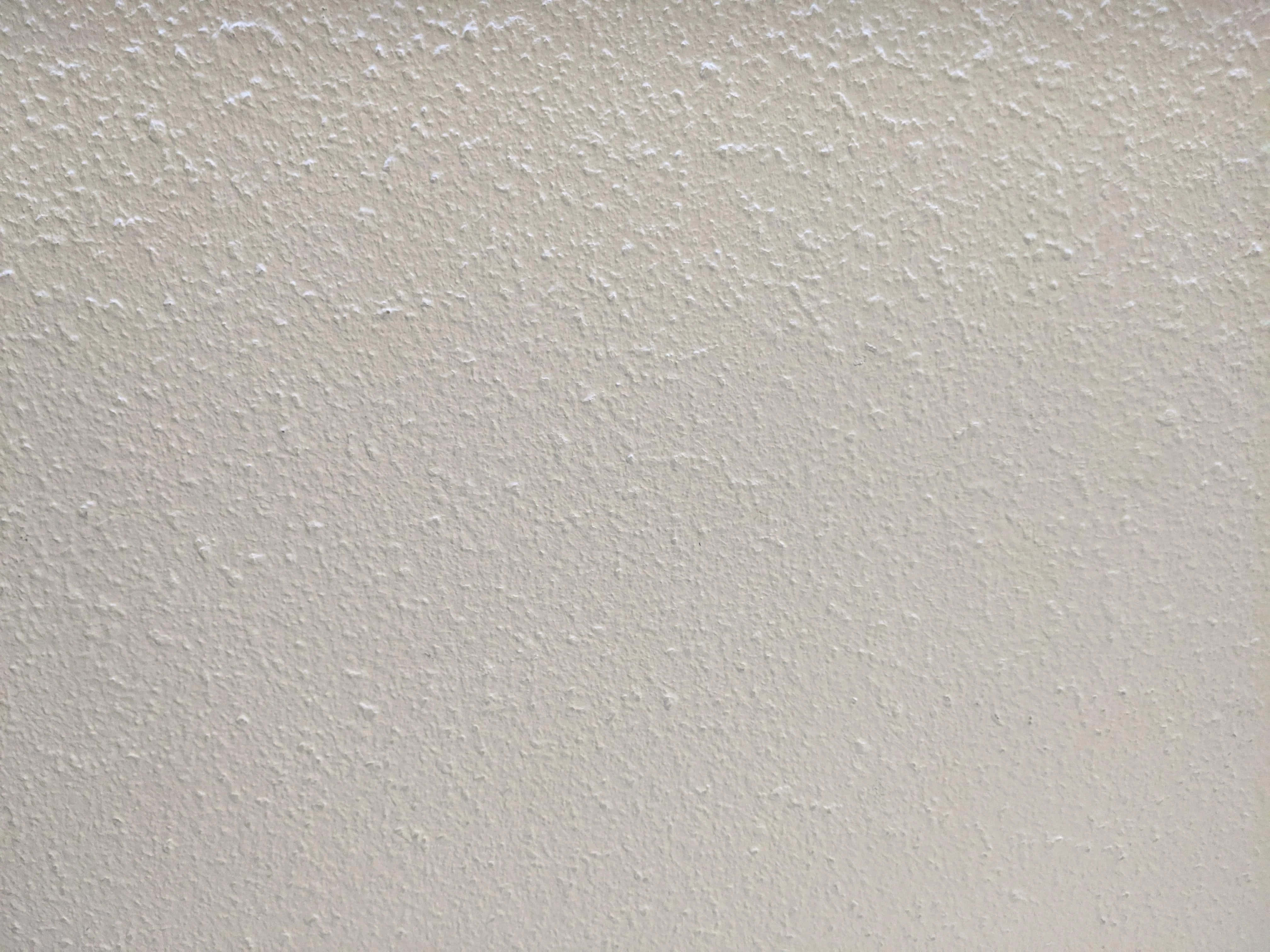Cement 桌布 壁紙 — 光滑米白色灰泥牆的近距離特寫，帶有細微紋理和均勻光線。