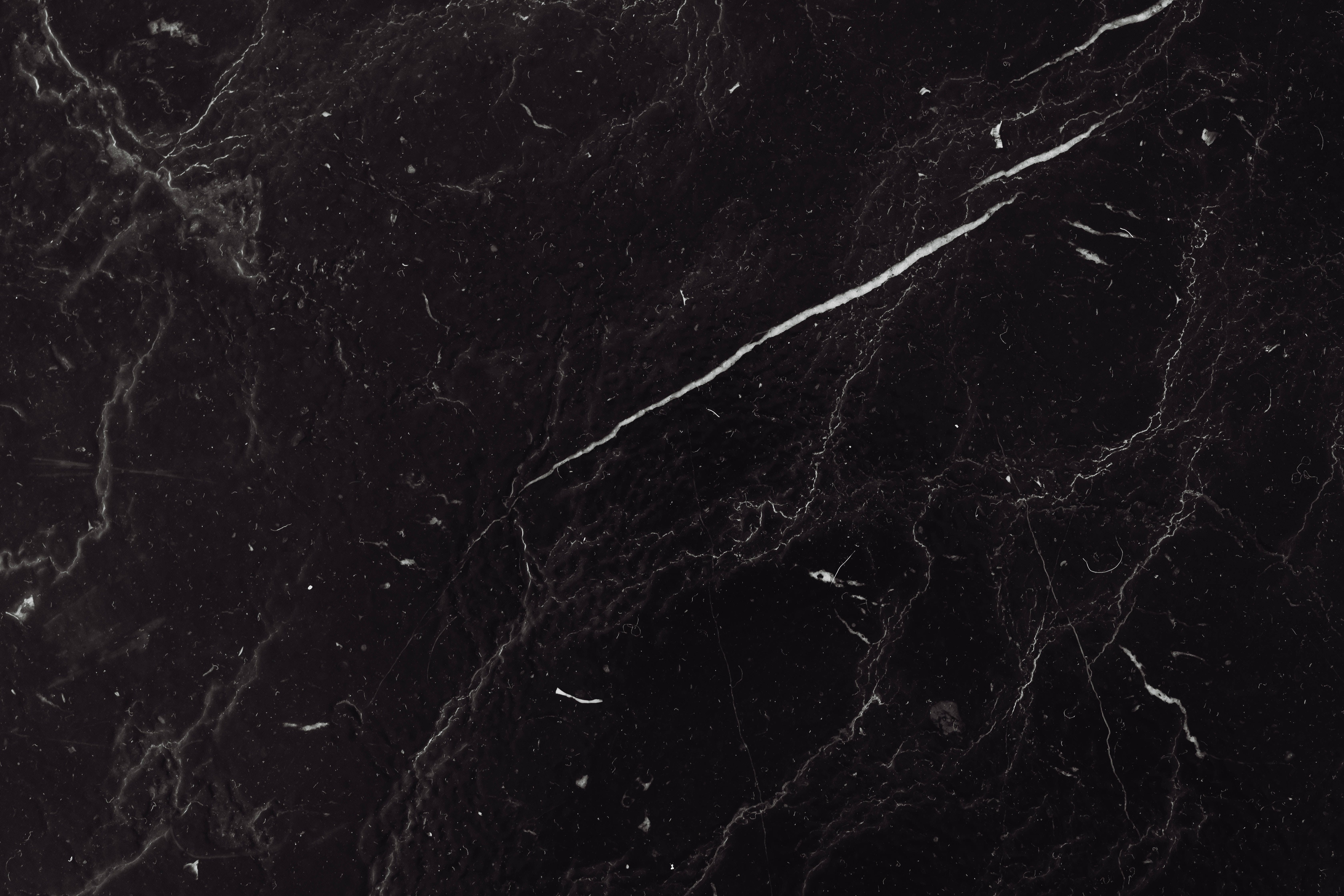 Black Marble 4K 桌布 壁紙 — 光滑黑色大理石的近距離特寫，帶有複雜的白色紋理和微妙的灰色底色。