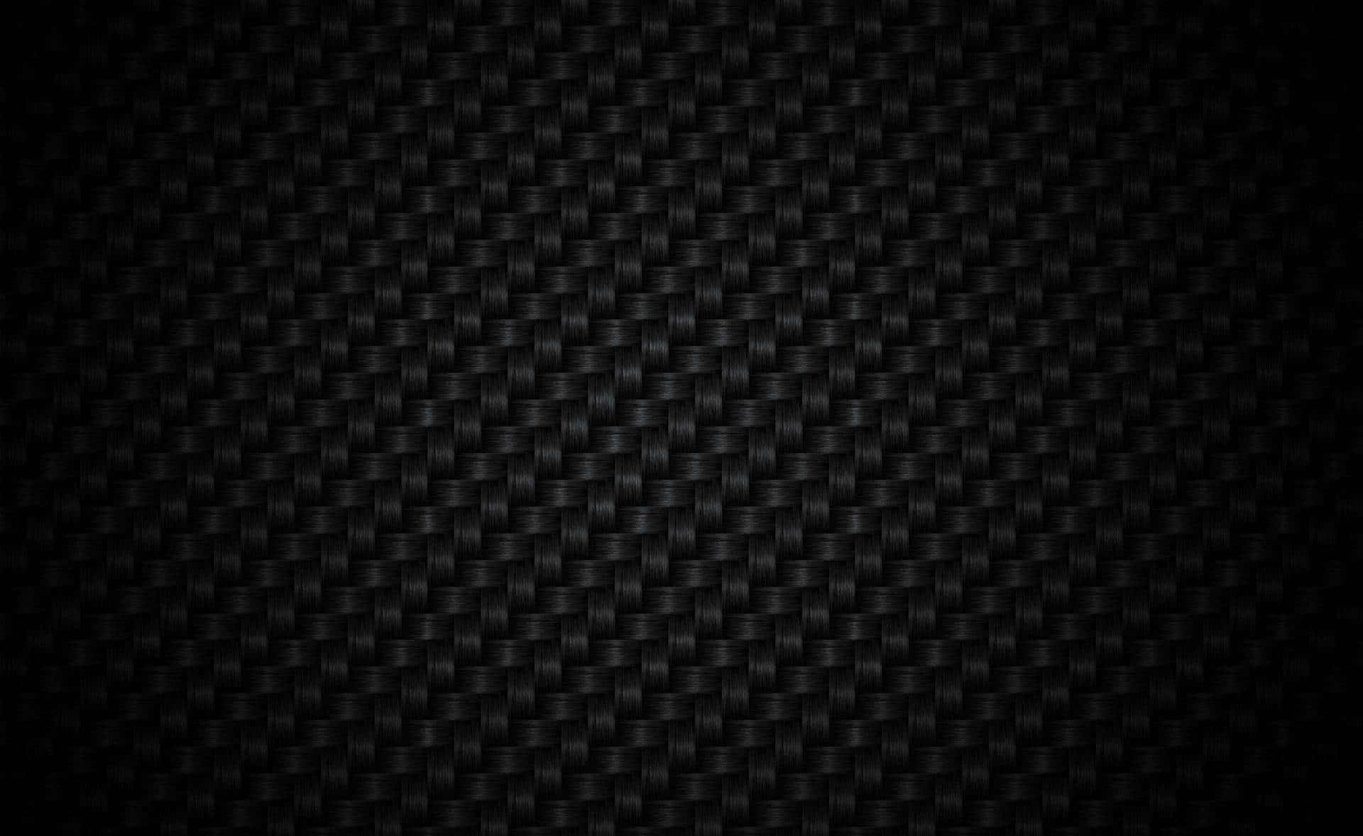 Black And White Texture 桌布 壁紙 — 光滑黑色碳纖維紋理的近距離特寫，帶有細微編織圖案和漸變照明。