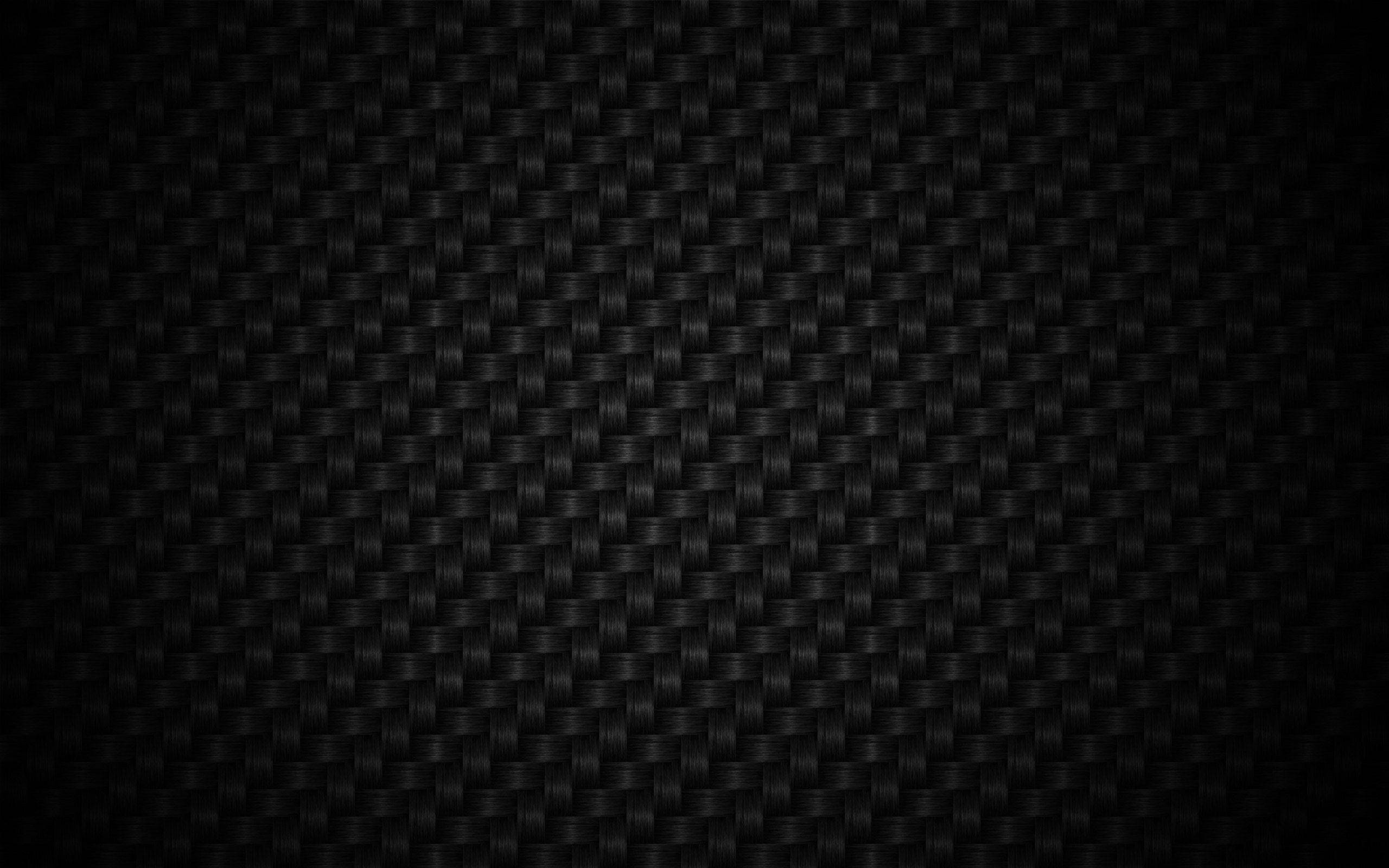 Screen 桌布 壁紙 — 光滑黑色碳纖維紋理的近距離特寫，帶有細微的編織圖案和漸變照明。