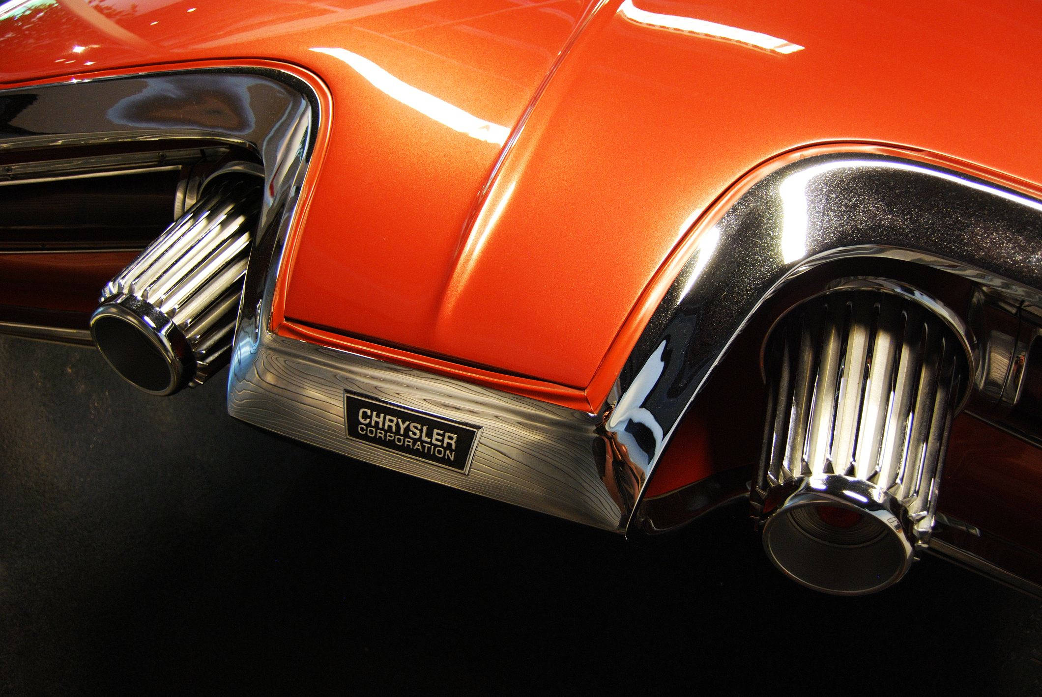 Chrysler 桌布 壁紙 — 光澤橙色經典汽車後部的特寫，帶有鍍鉻排氣管和'Chrysler Corporation'徽章。