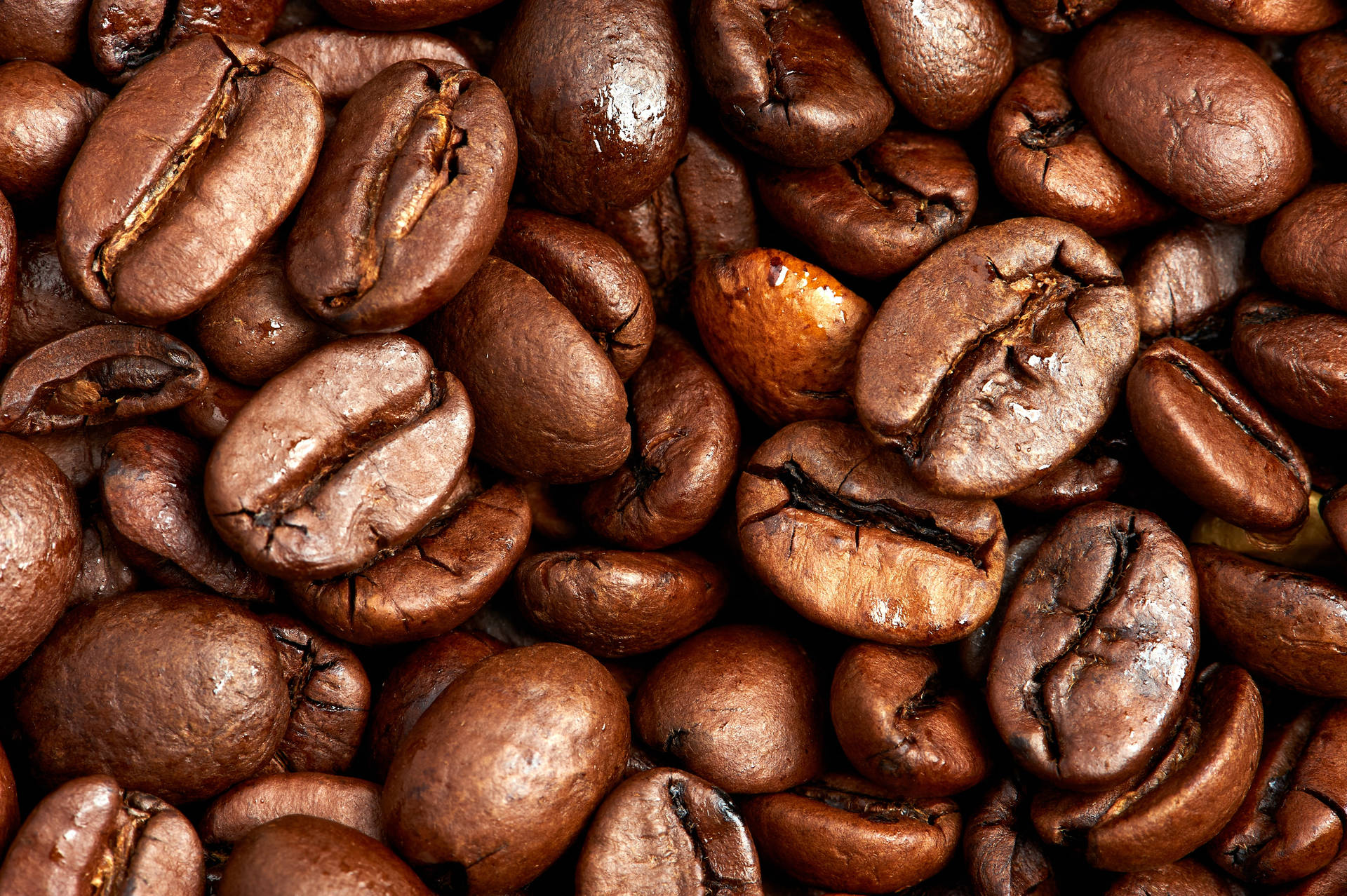 beans 桌布 壁紙 — 光澤烘焙咖啡豆的特寫，帶有豐富的棕色色調和可見裂紋。
