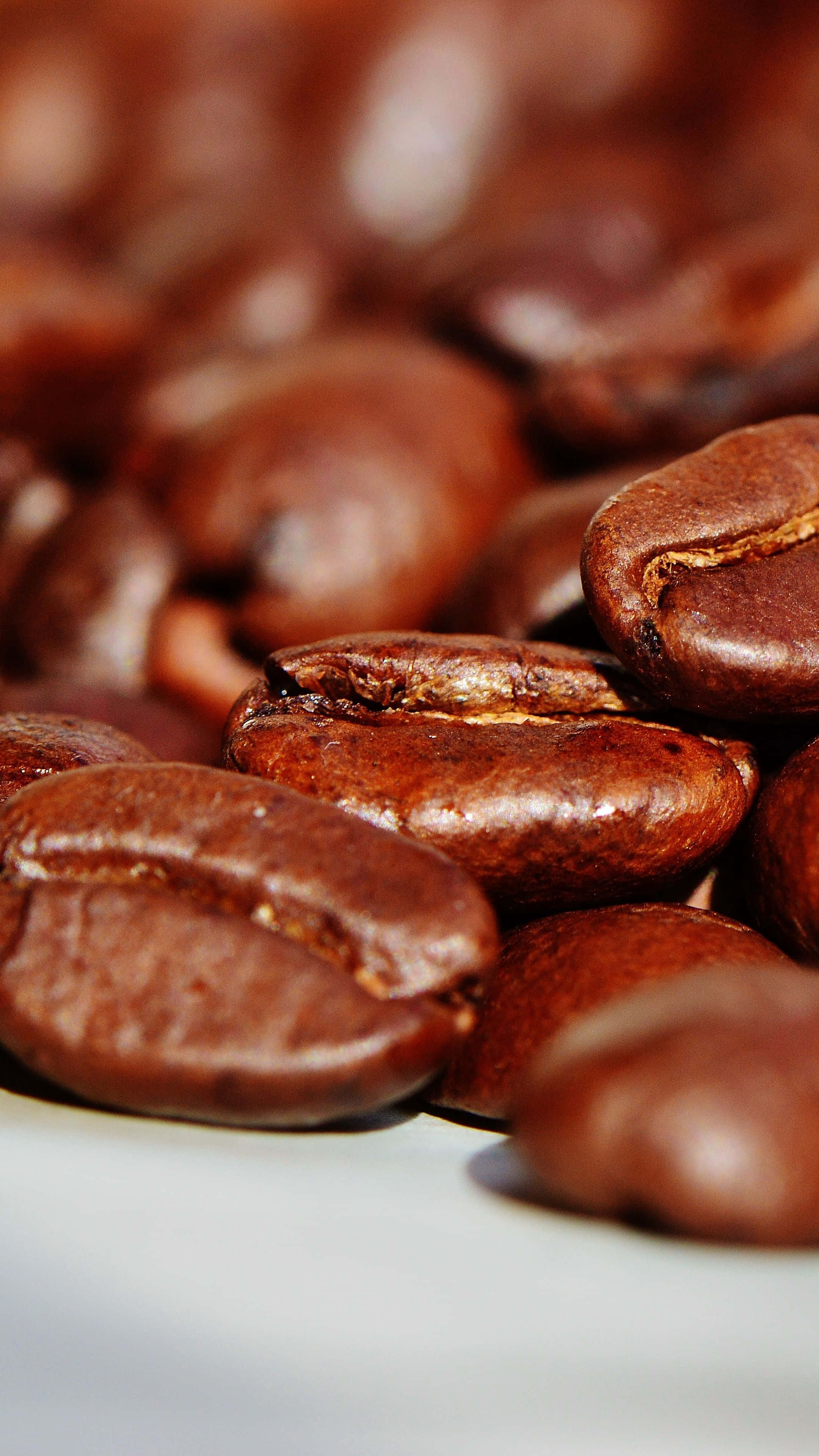 Coffee Beans 桌布 壁紙 — 光澤烘焙咖啡豆的特寫，帶有豐富的棕色色調和淺景深。