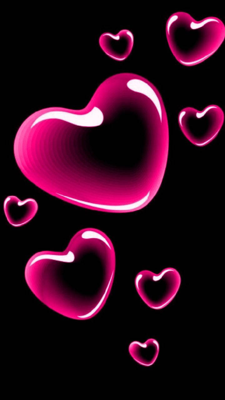 Love Phone 桌布 壁紙 — 光澤粉紅心形漂浮在黑色背景上，帶有明亮高光和柔和陰影。