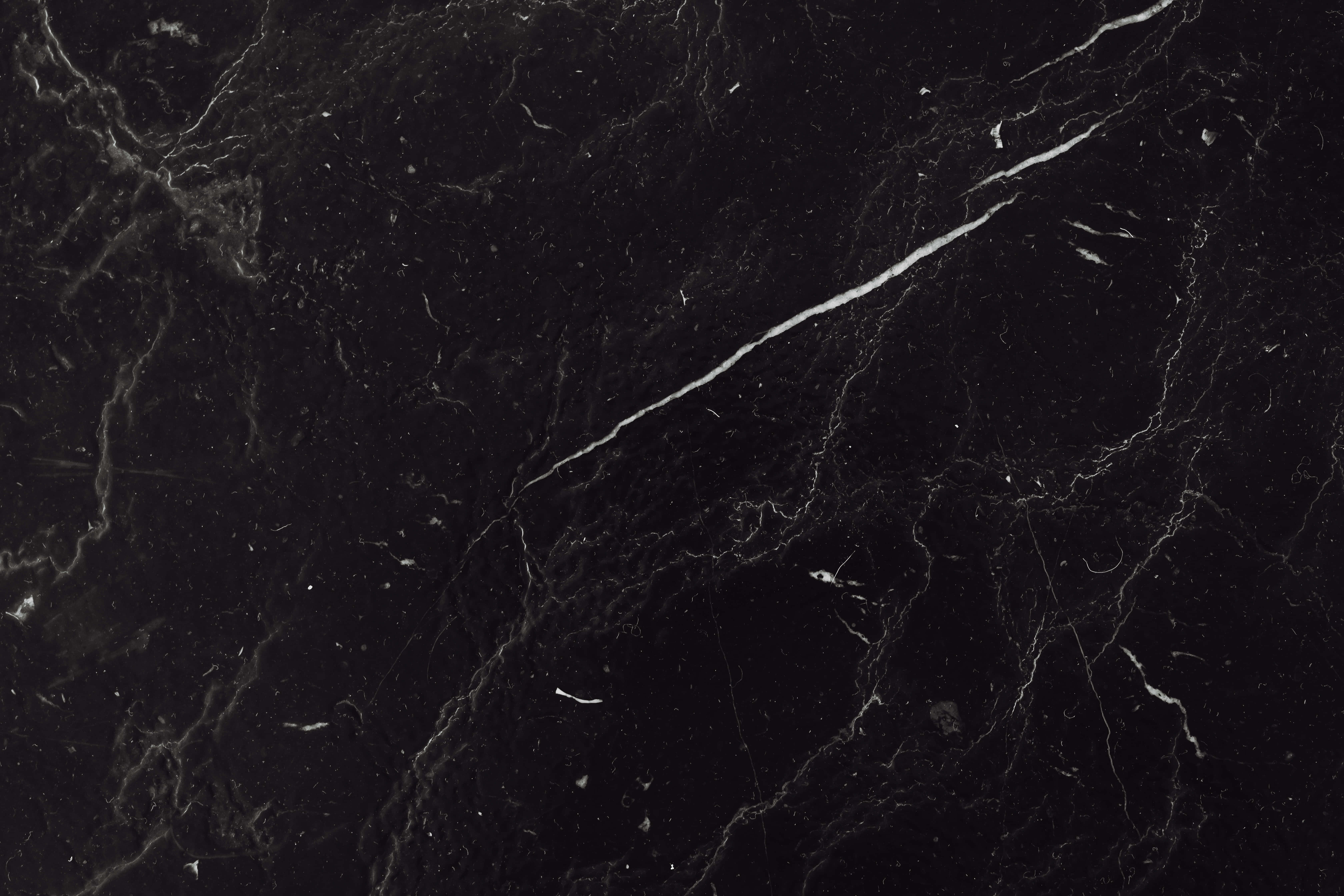 Black And White Marble 桌布 壁紙 — 光澤黑色大理石的近距離特寫，帶有複雜的白色和灰色紋理，營造出奢華的自然圖案。